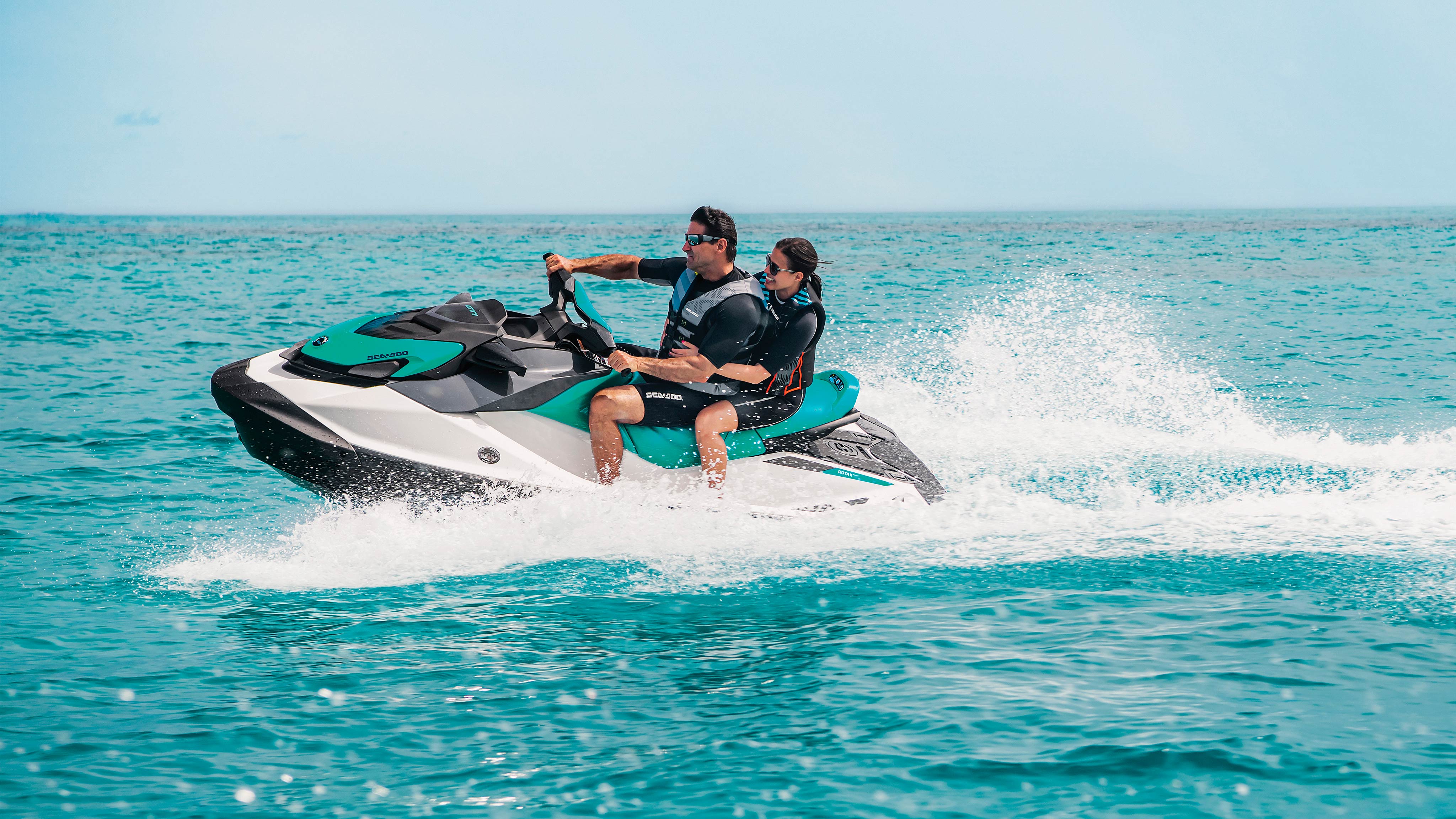 A man and a woman riding a Sea-Doo GTI