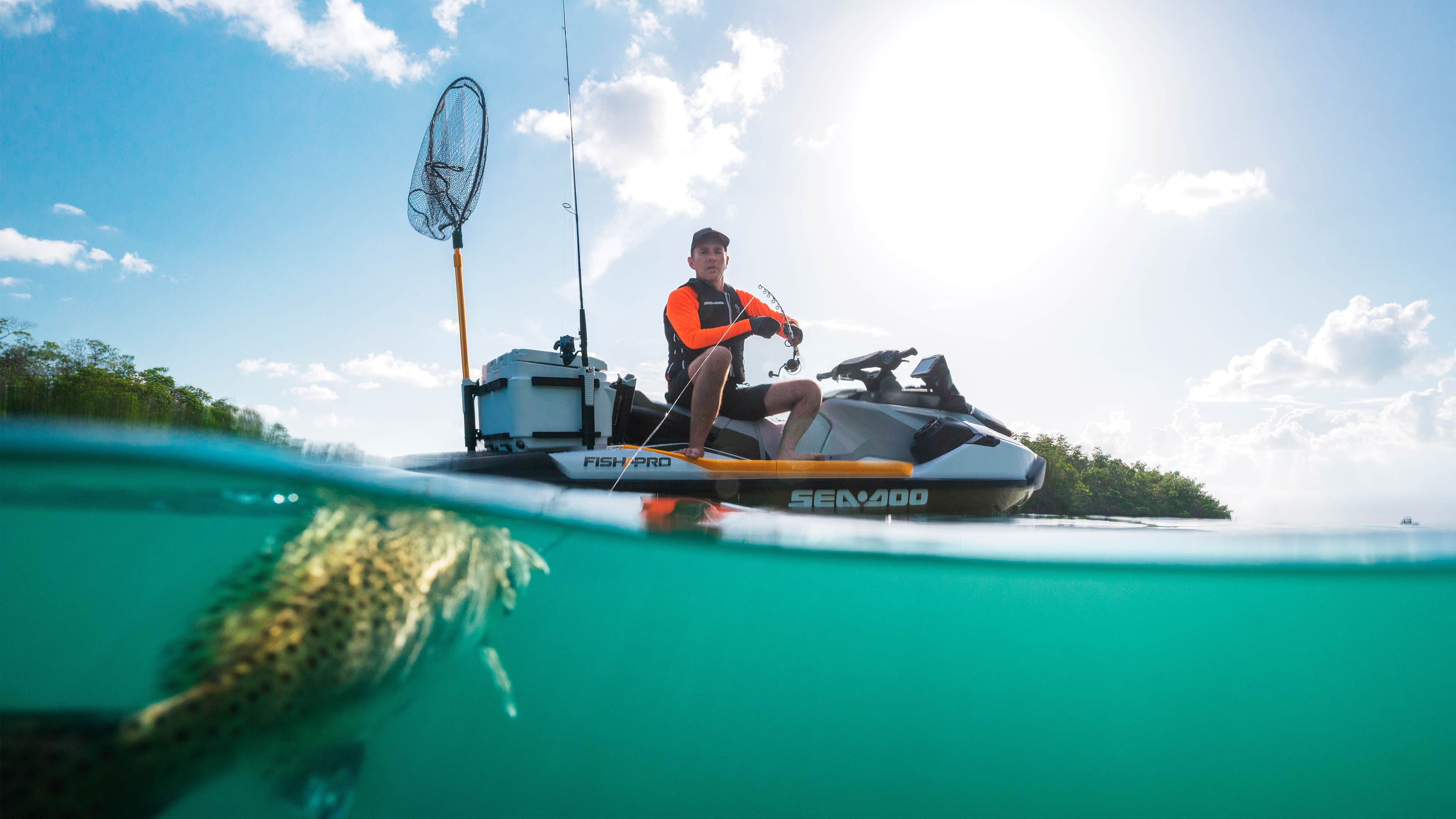 Man reeling a fish while sitted on his Sea-Doo Fish Pro