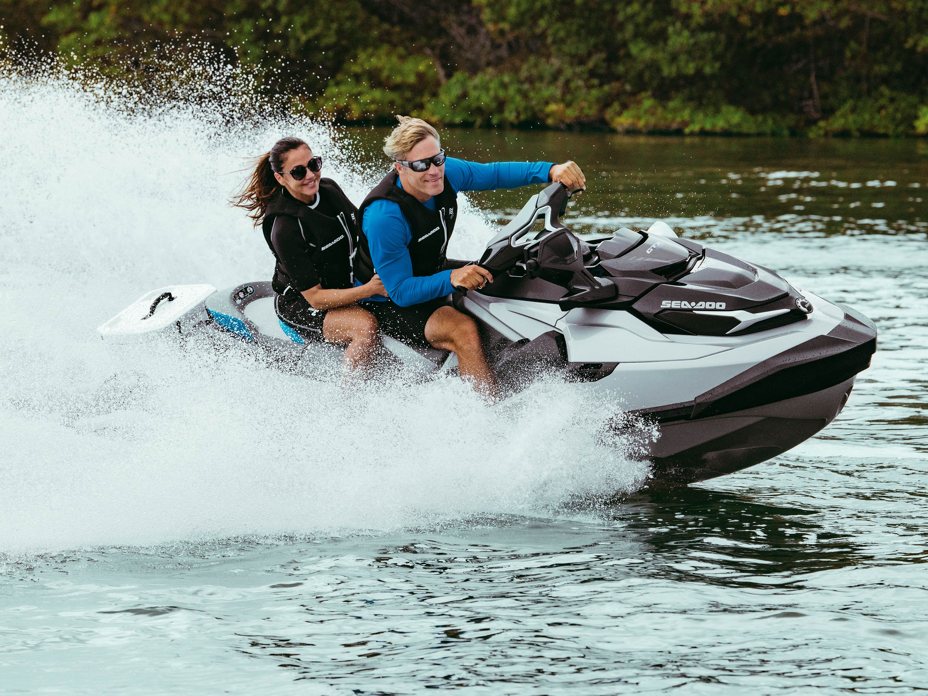 Two women doing karate while standing up on a Sea-Doo GTX Limited