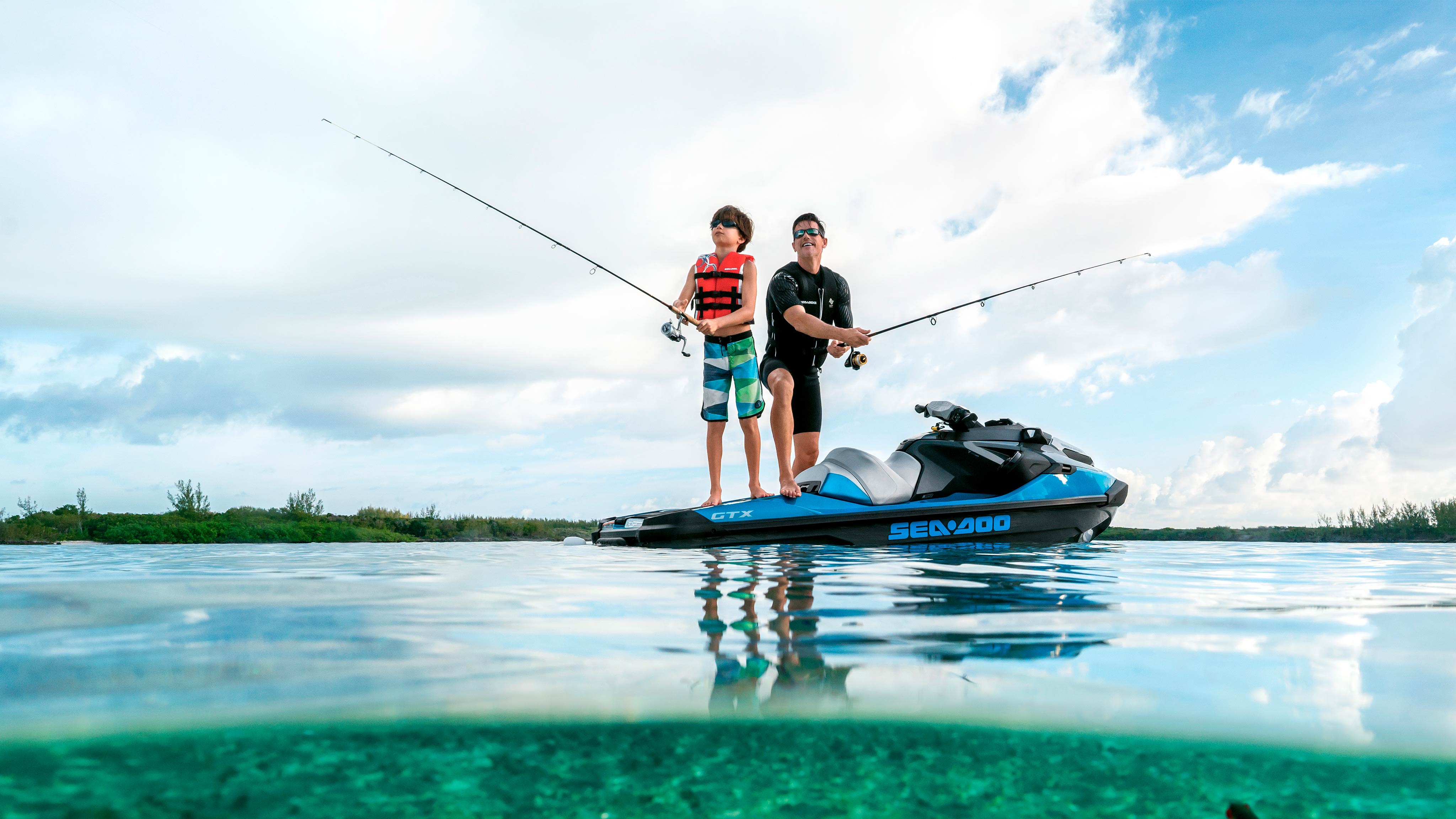 Njeriu dhe djali i tij peshkojnë duke qëndruar në një Sea-Doo GTX