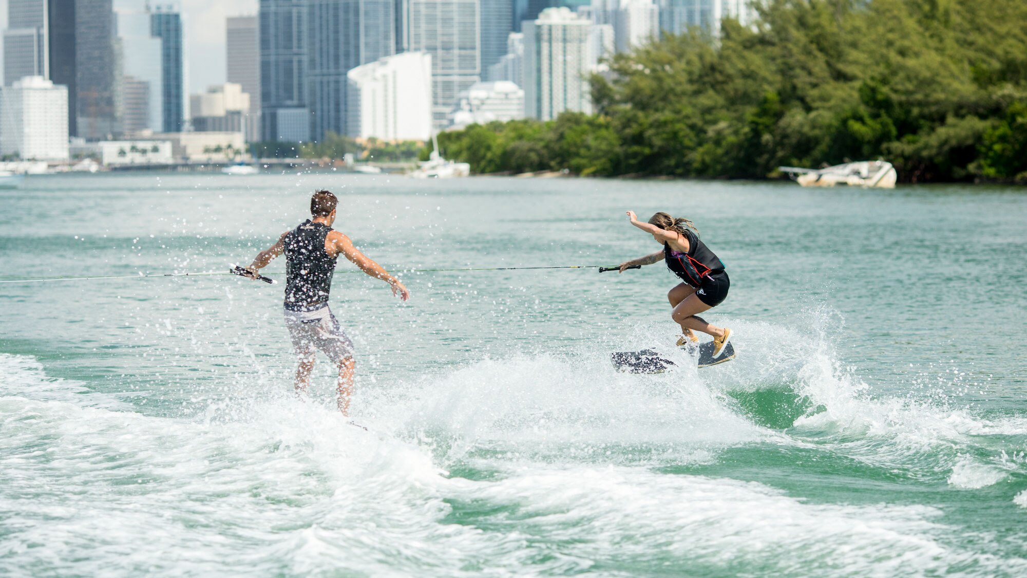 2 people Wakeskating in the back of a Sea-Doo watercraft