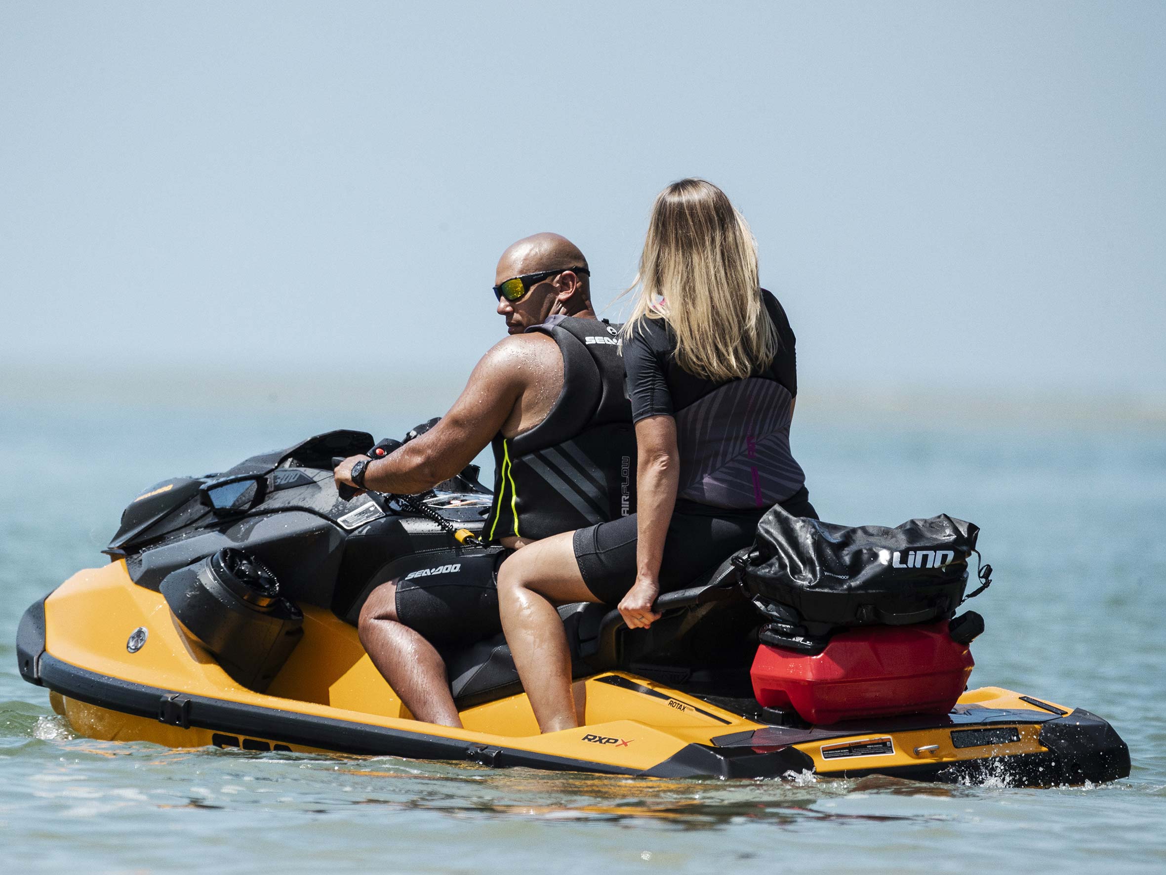 Couple riding a Sea-Doo RXP-X with a LinQ system