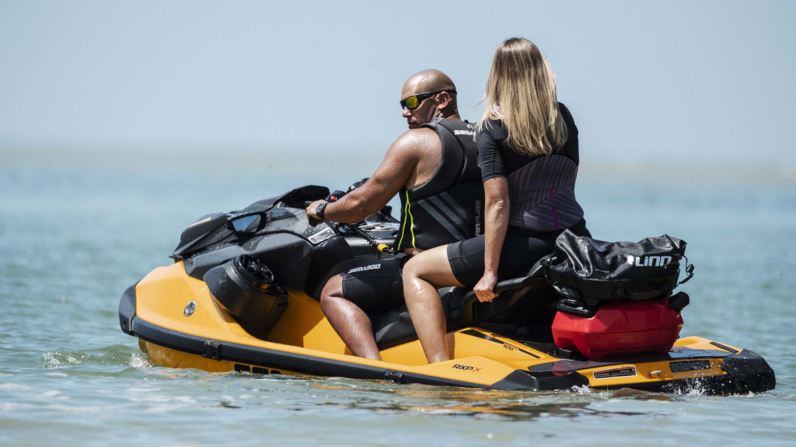 Couple riding a Sea-Doo RXP-X with a LinQ system