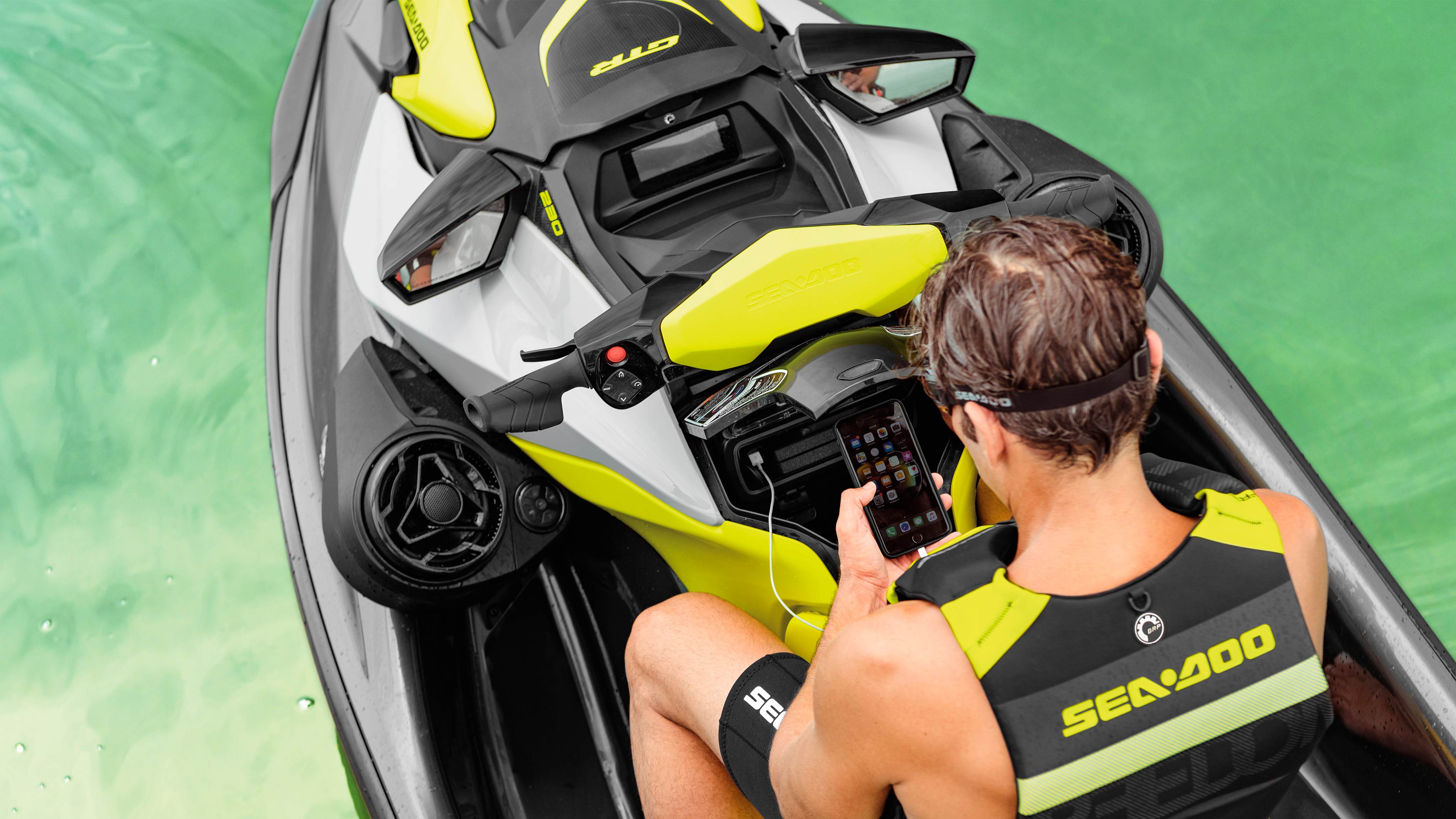 Férfi ül a  Sea-Doo GTR telefonját nézi