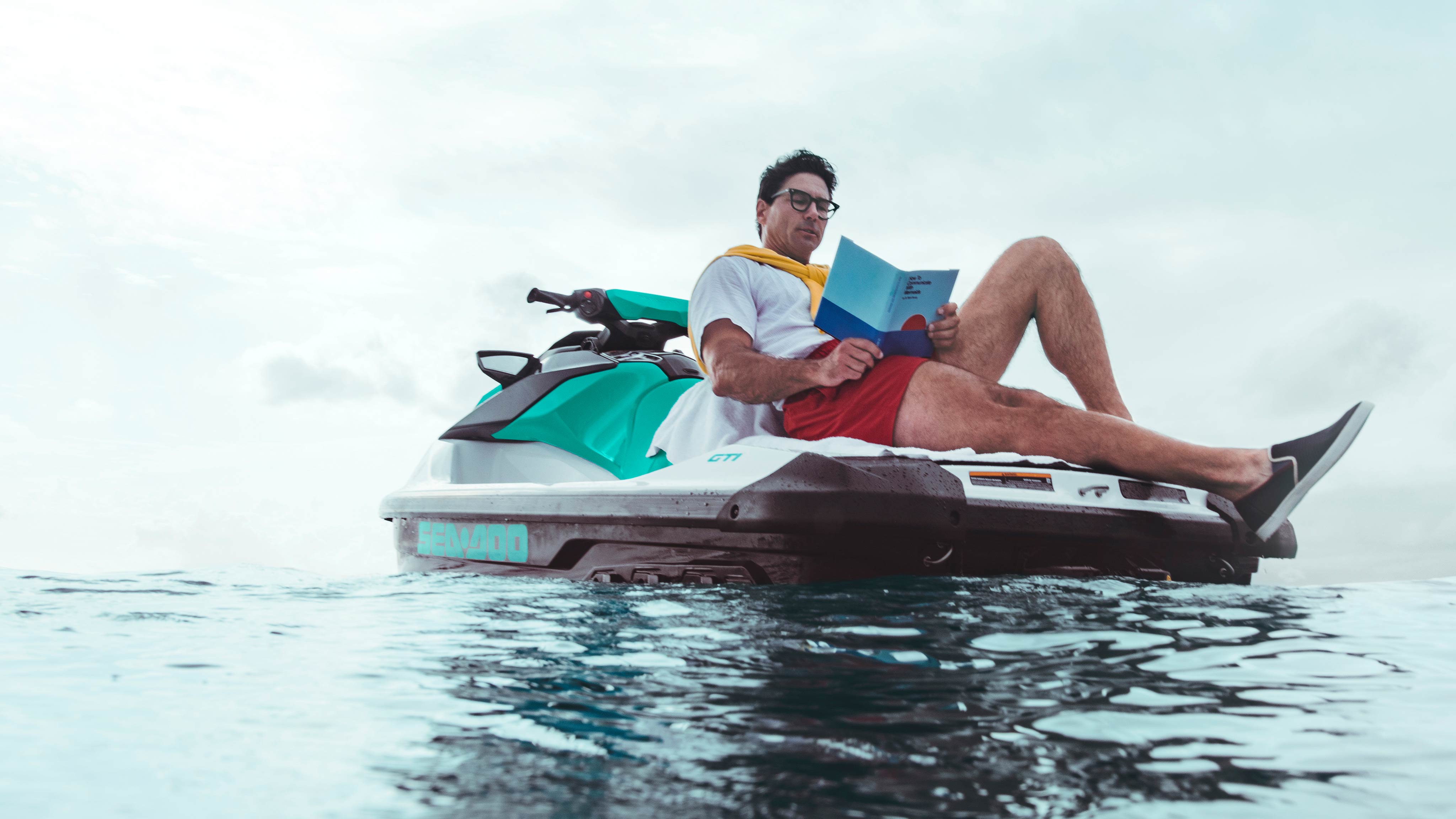 Man reading a book from the Sea-Doo GTI back swim platform