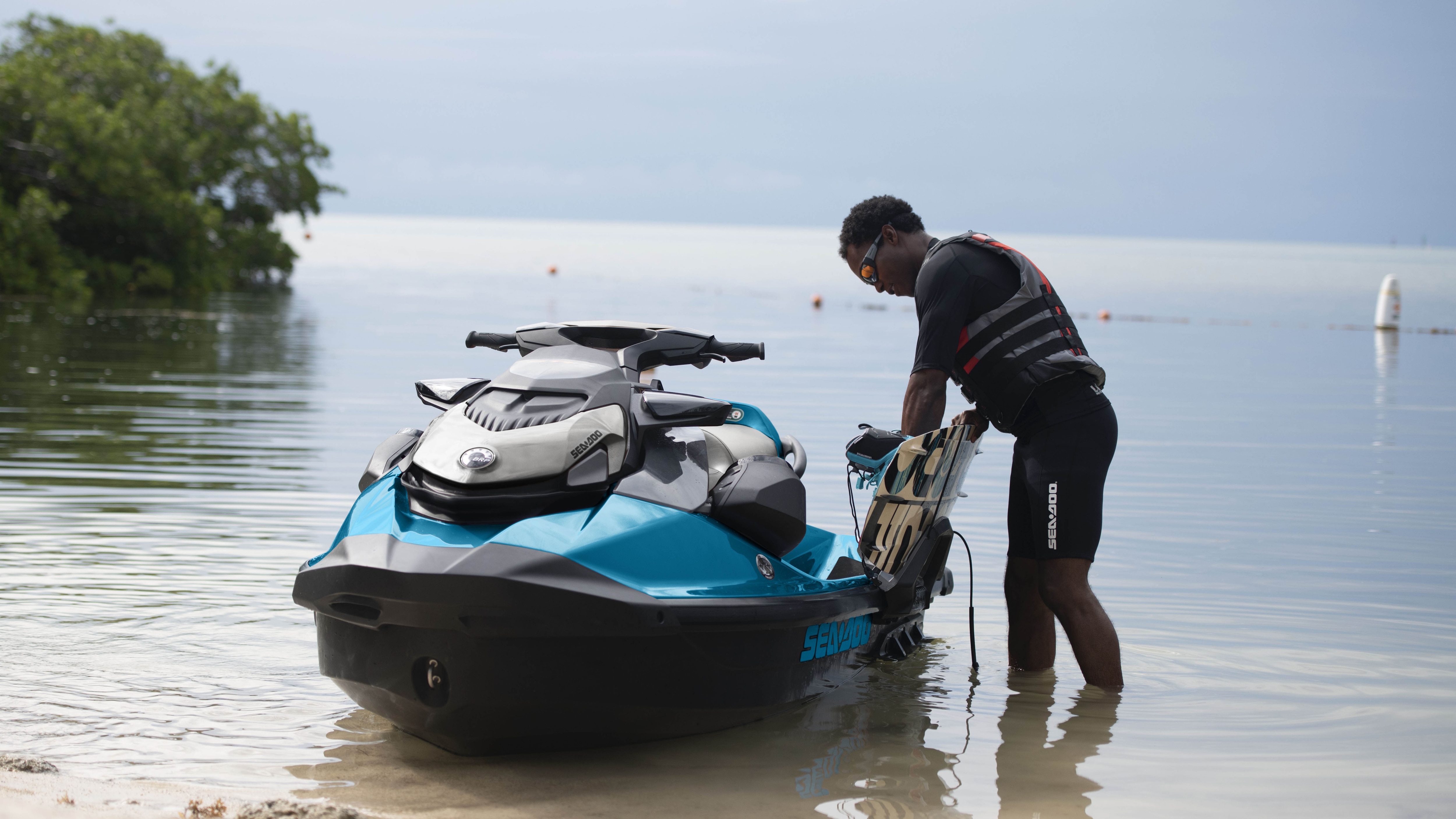 Man fixing wakeboard on the Sea-Doo GTI SE Polytec hull