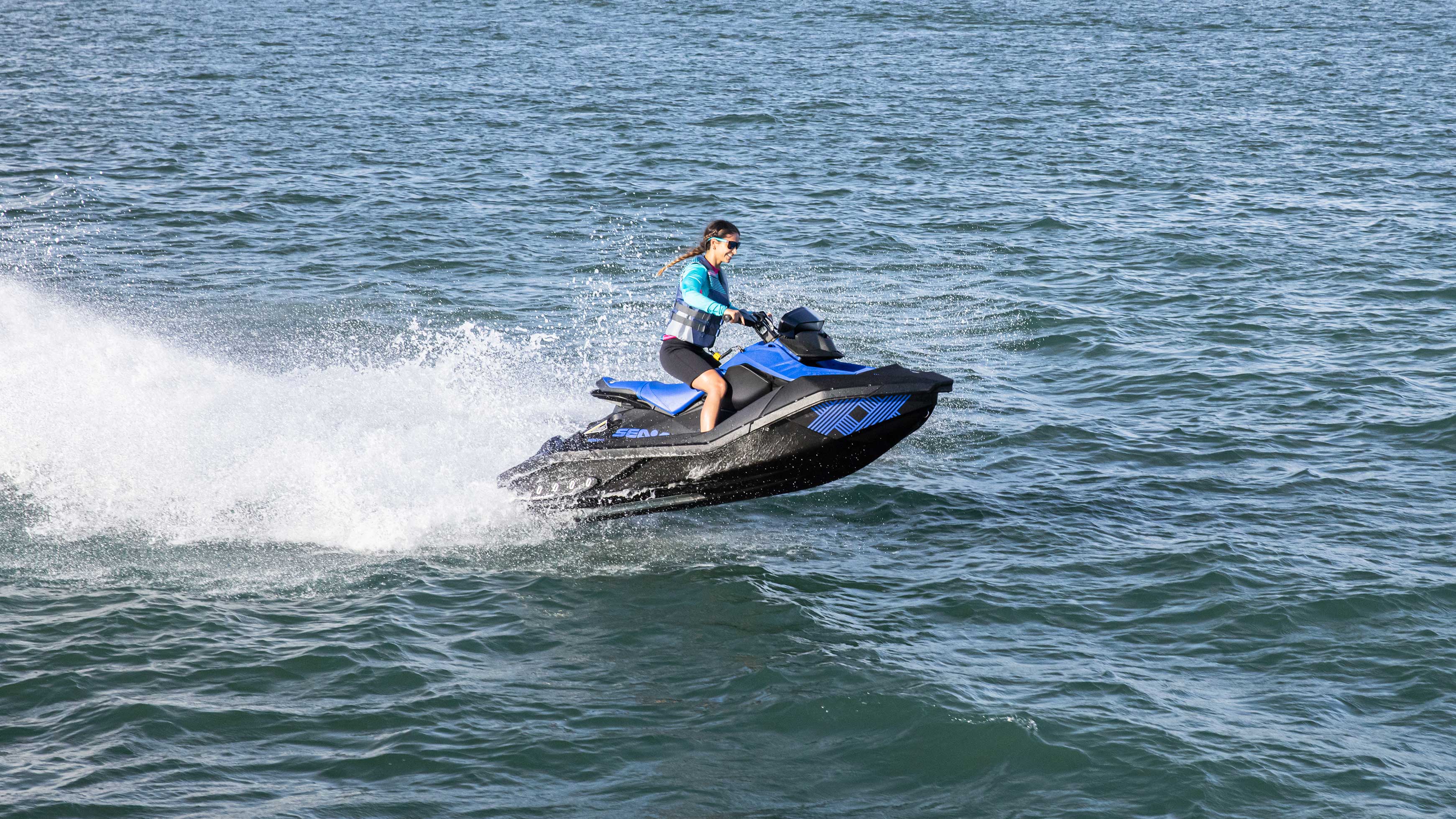 Nő halad a kék Sea-Doo Spark Trixx modellel