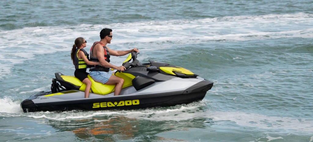 Момче и девојка кои уживаат во возењето на нивното Sea-Doo пловило на Хаваи.