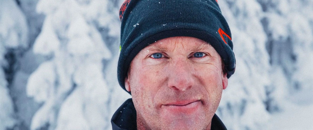 Man smiling near a snowy forest