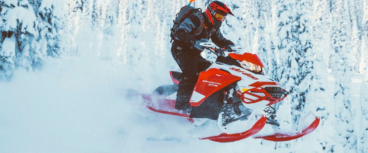 Man jumping through snow with his Ski-Doo Backcountry