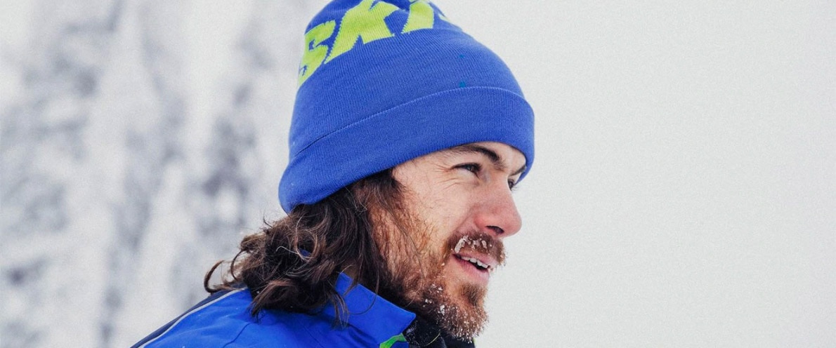 Man smiling near a snowy forest