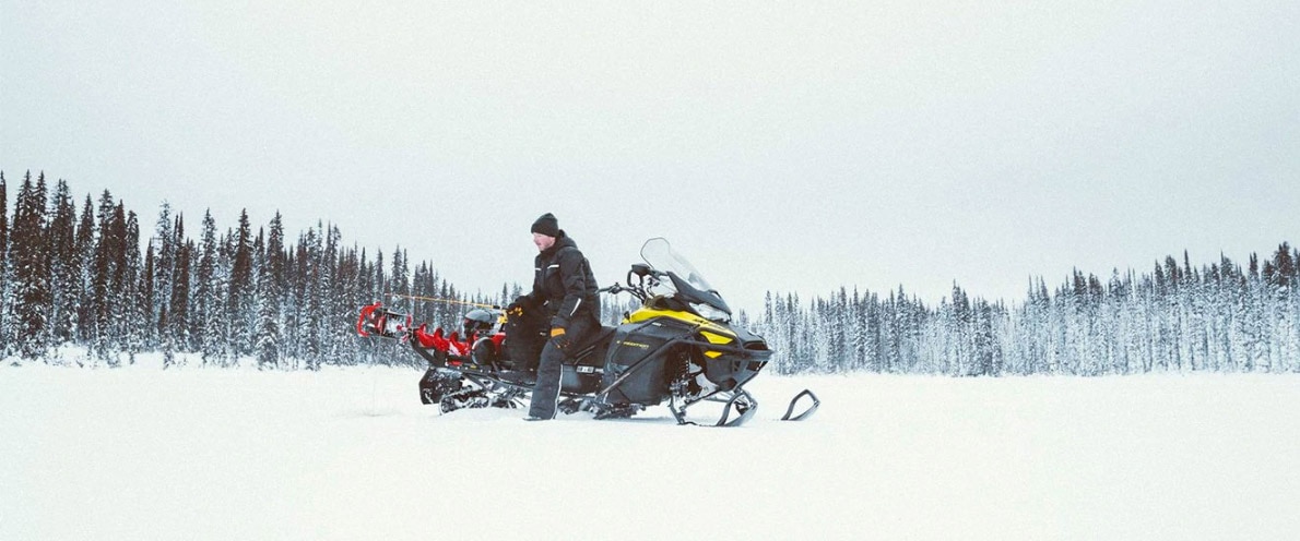 Človek, ki lovi, medtem ko sedi na svoji ekspediciji Ski-Doo