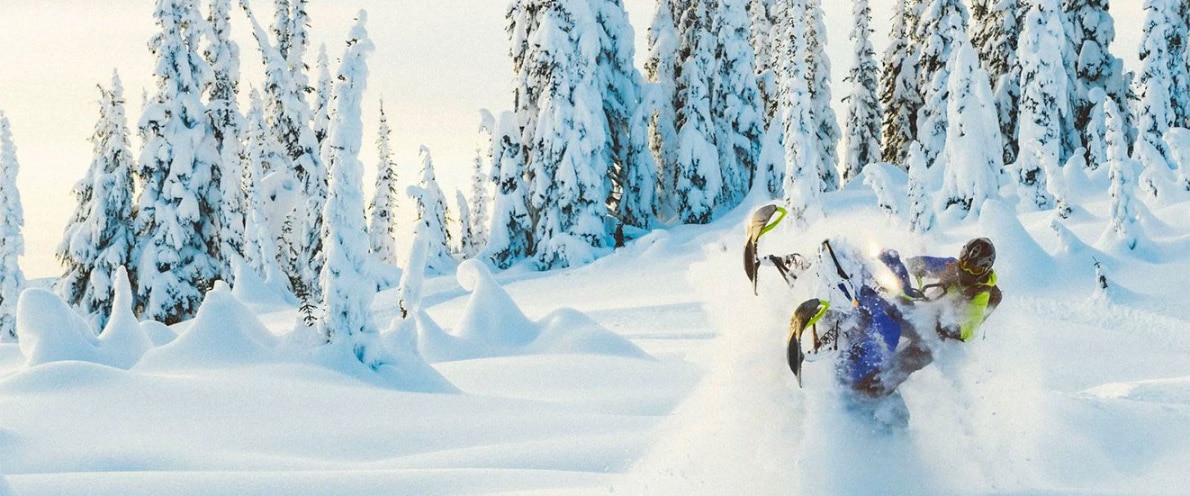 Man jumping through the air with his snowmobile