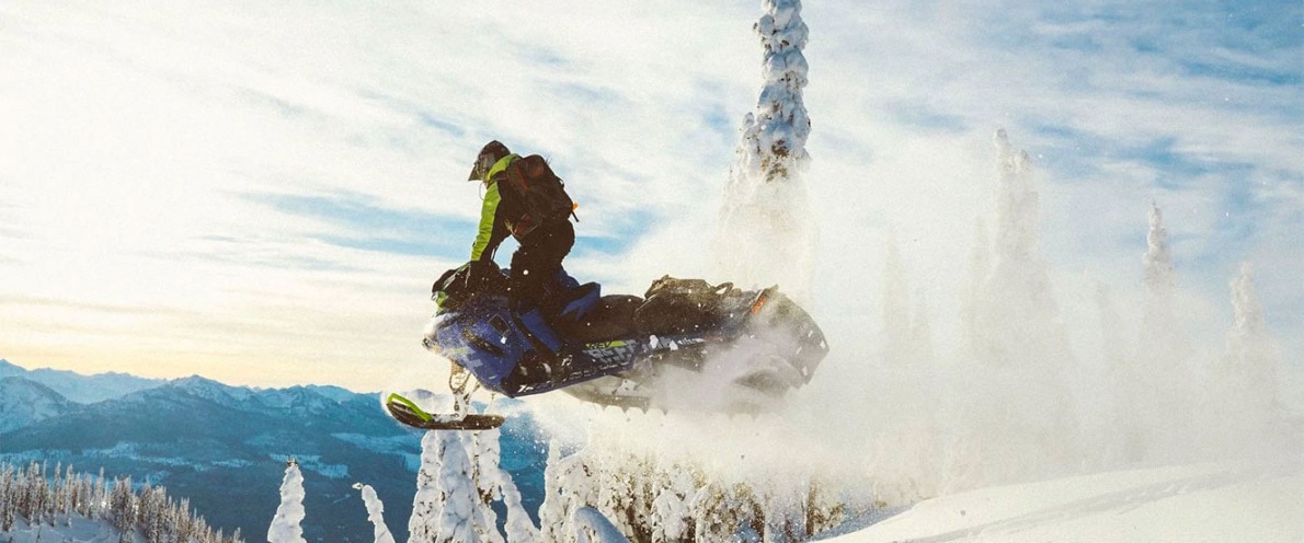 Man about to land with his snowmobile