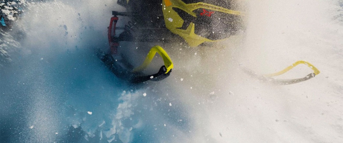 Človek, ki pluje po snegu s svojim Ski-Doo MXZ Človek skače skozi sneg s svojim Ski-Doo MXZ