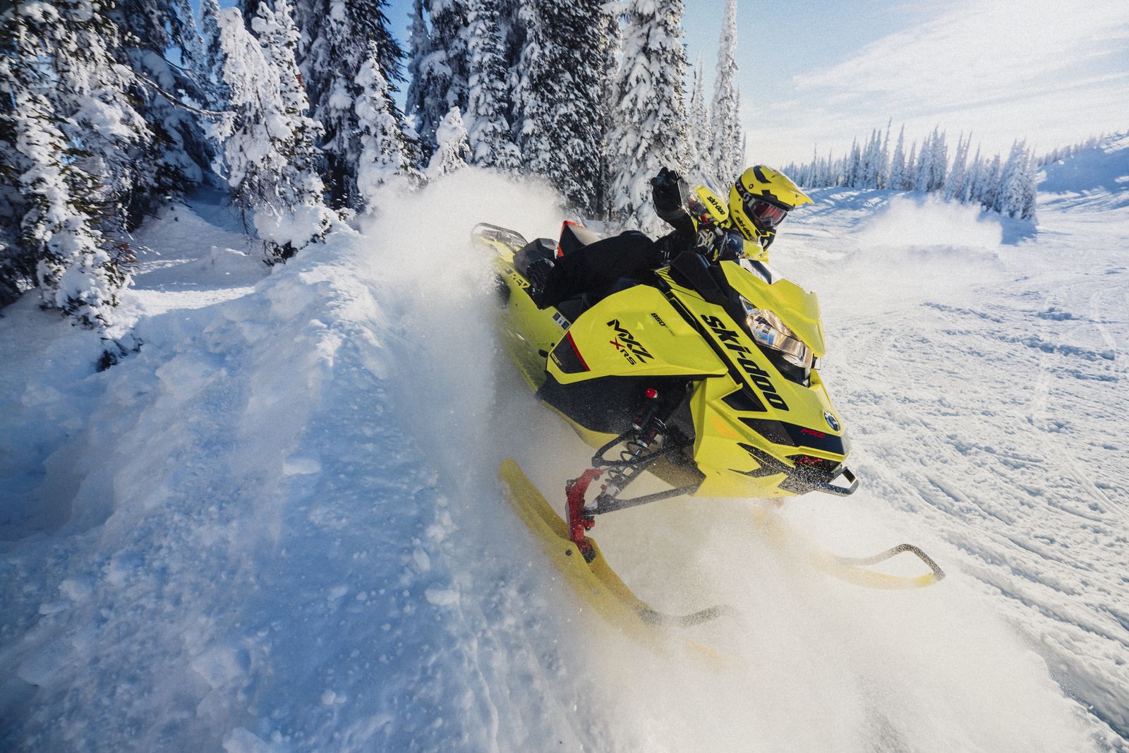 Muž driftující na sněhu se svým sněžným skútrem Ski-Doo MXZ