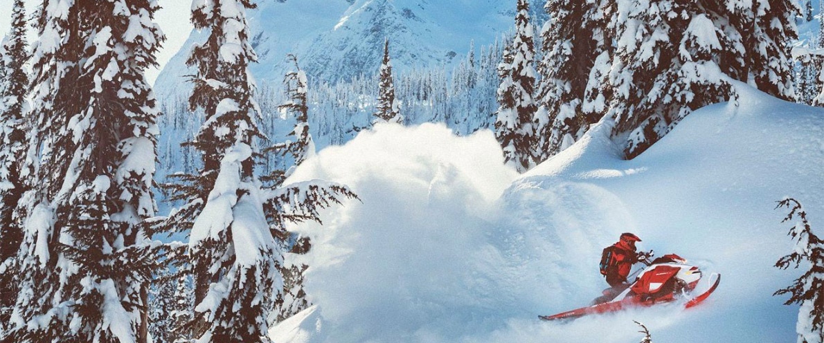 Man drifting in snow with his Summit snowmobile