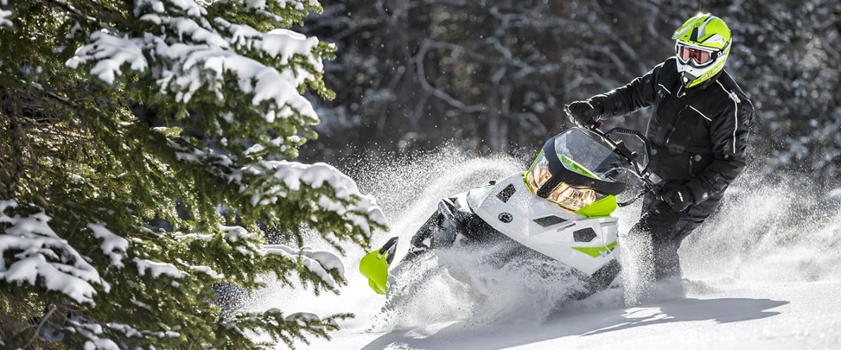 Man standing up while turning his Ski-Doo Tundra snowmobile