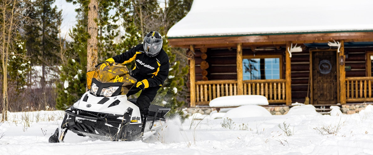 Muž odcházející od sněžného skútru Ski-Doo Tundra