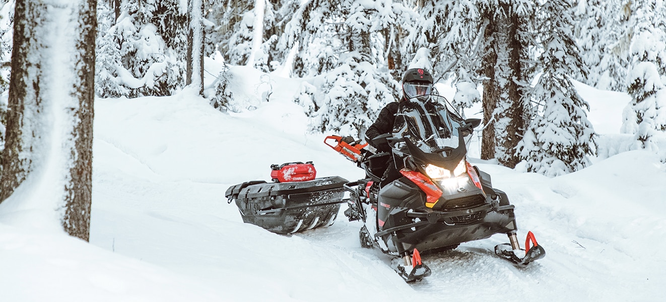 Moški vleče tovor z njegovimi Ski-Doo Skandic 