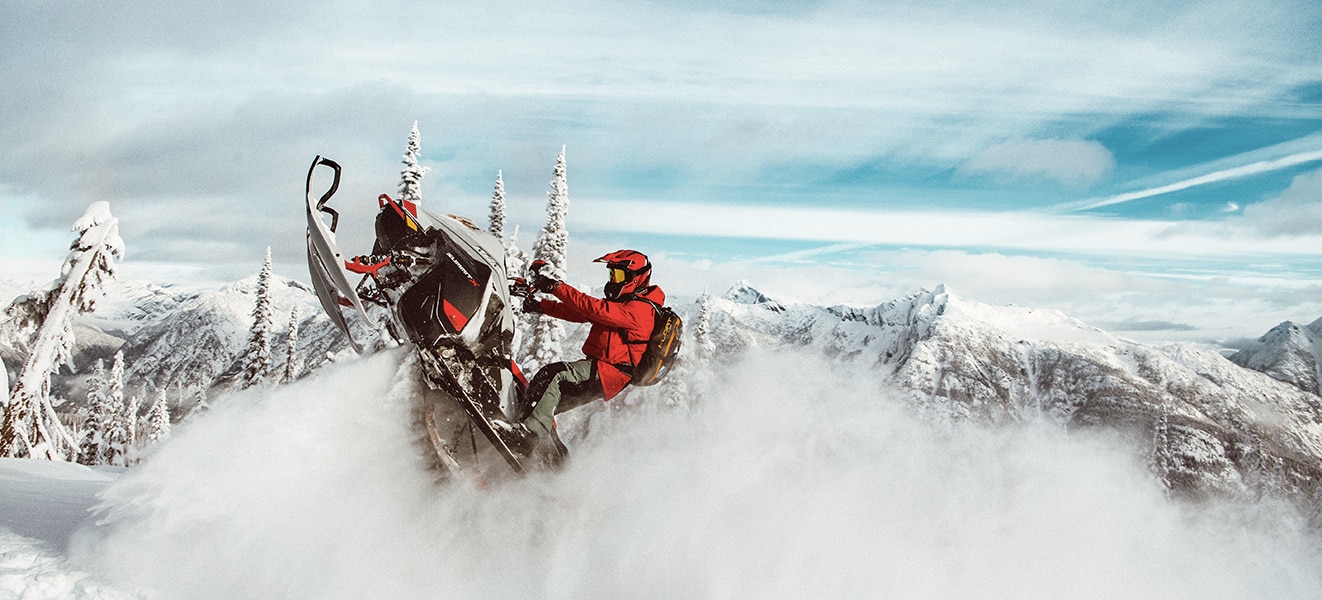 Moški skače po snegu z njegovimi Ski-Doo 2021 Summit