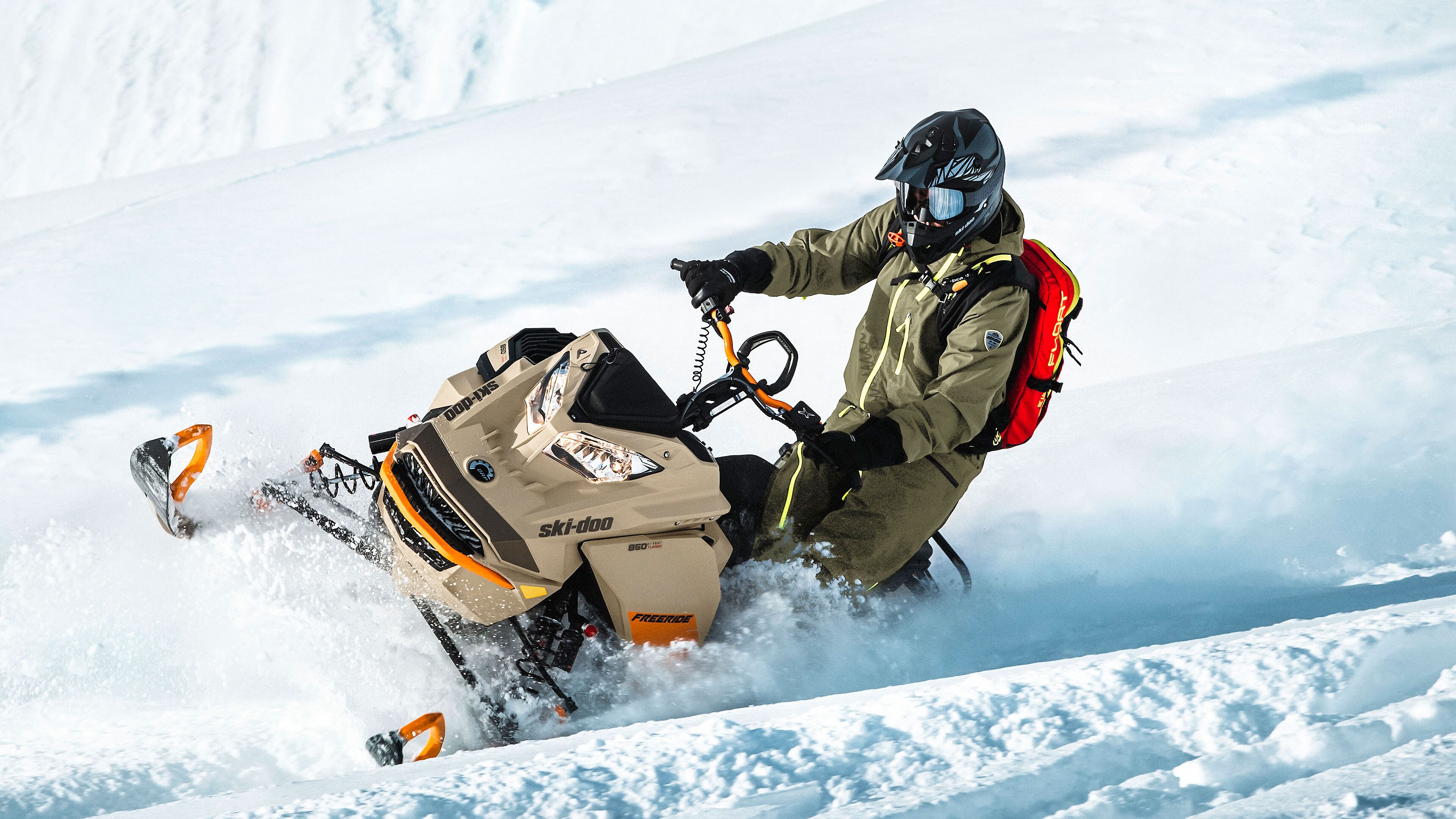 Uomo che cavalca la neve profonda con Ski-Doo Freeride