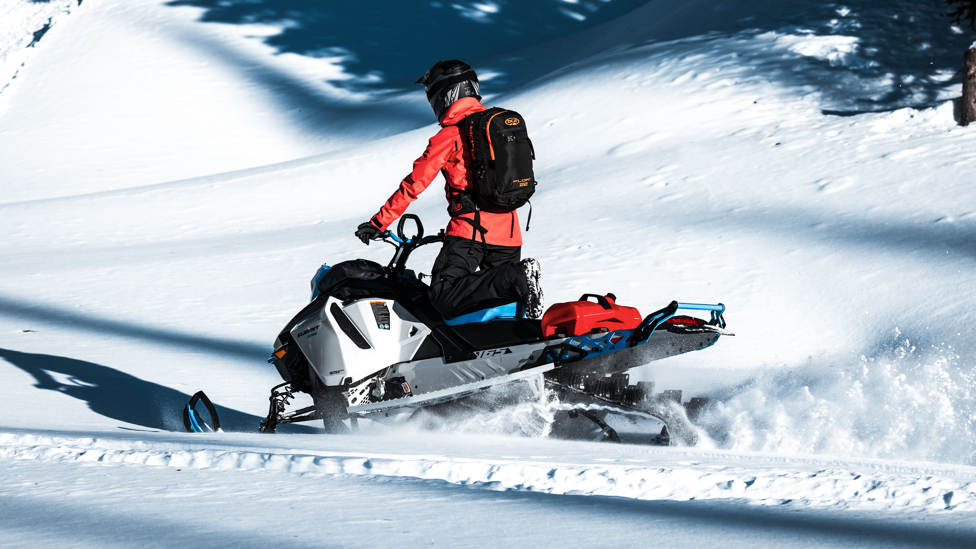 Uomo alla guida dello Ski-Doo Summit 2022 in montagna