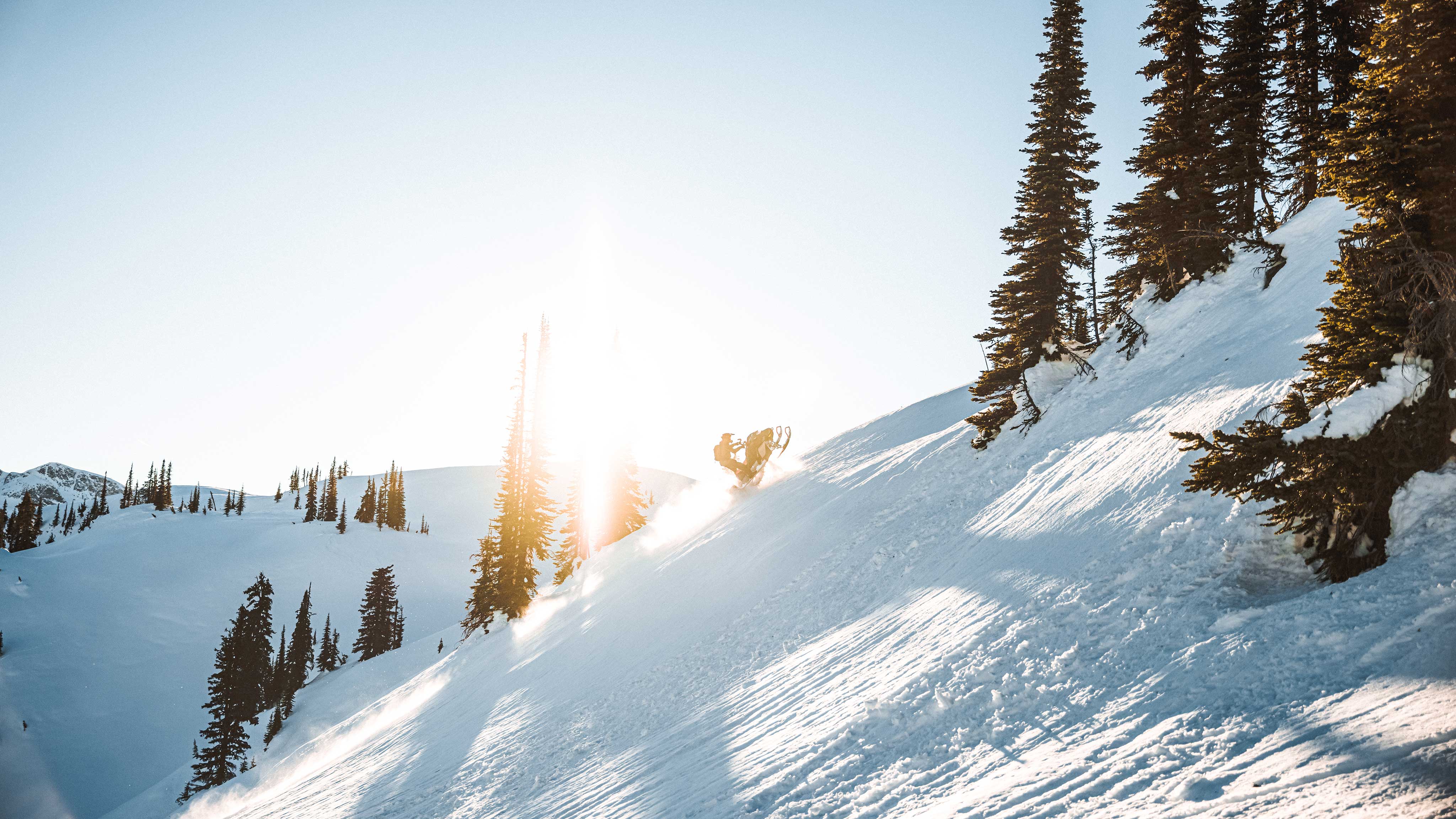 Man snowmobiling in moutain at sunset