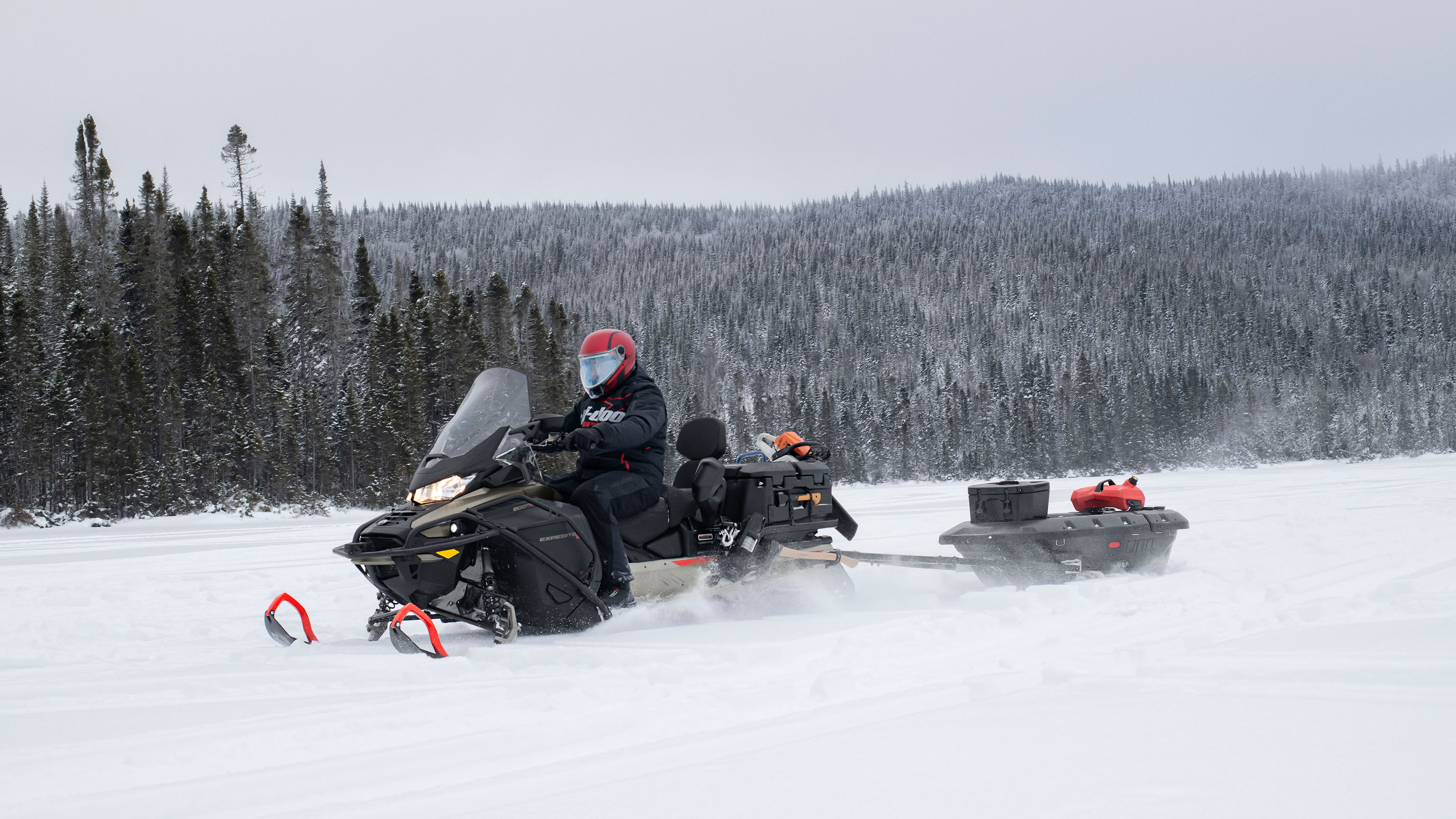 Man towing a sleigh with his 2022 Ski-Doo Expedition