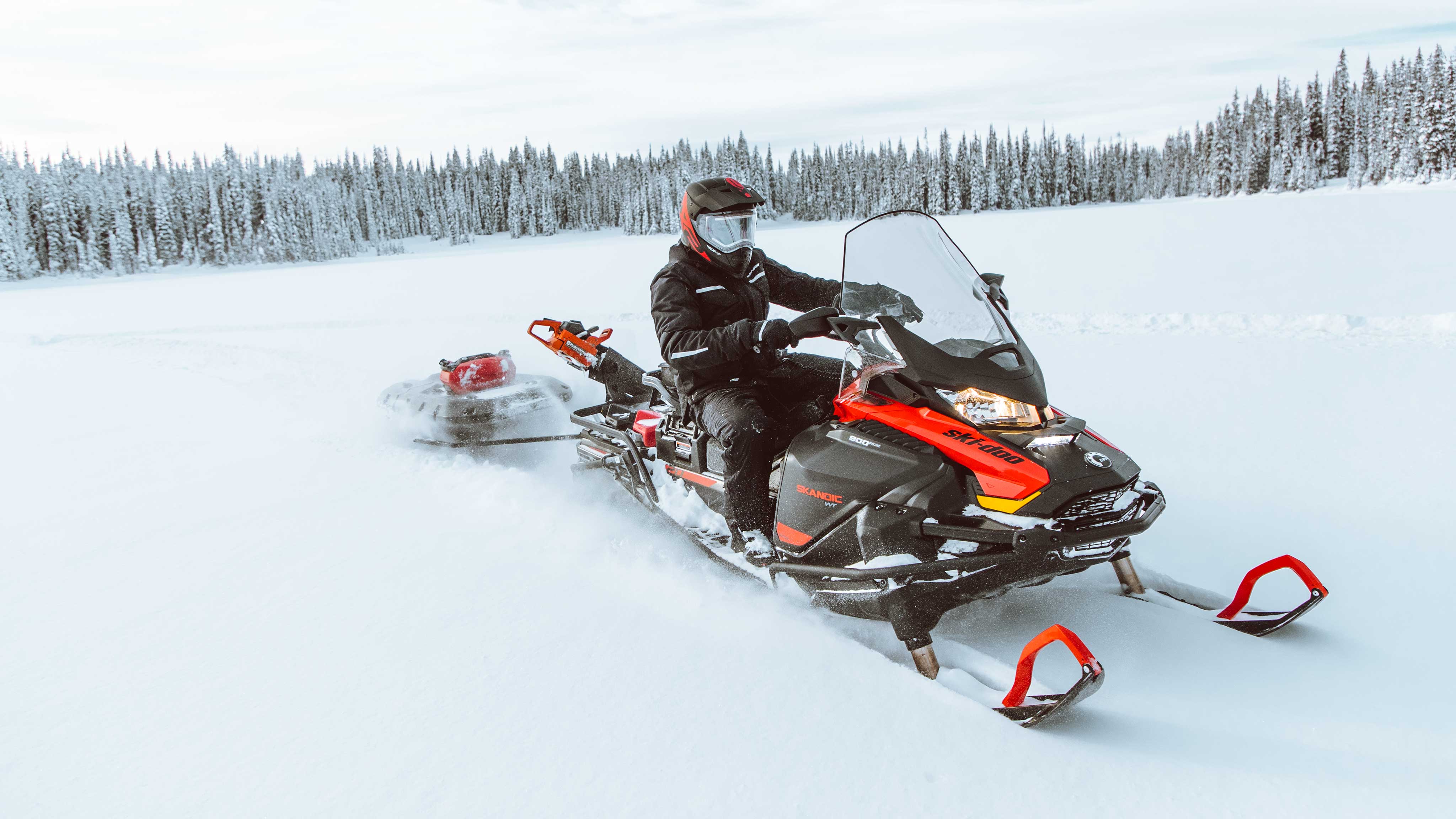 Man riding a Ski-Doo Skandic with sleigh in Deep-Snow