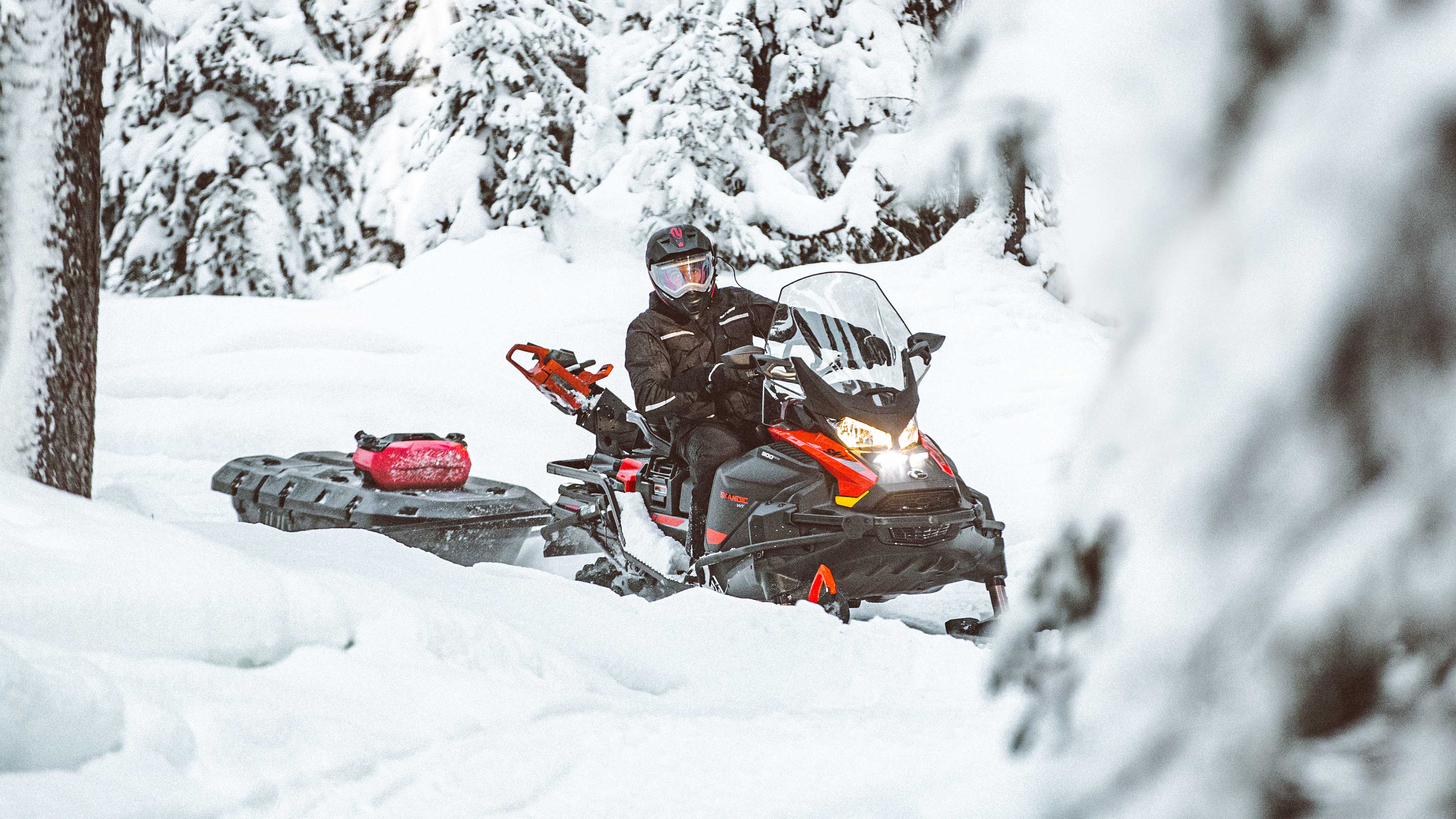 Man going to work with a Ski-Doo Skandic and a sleigh