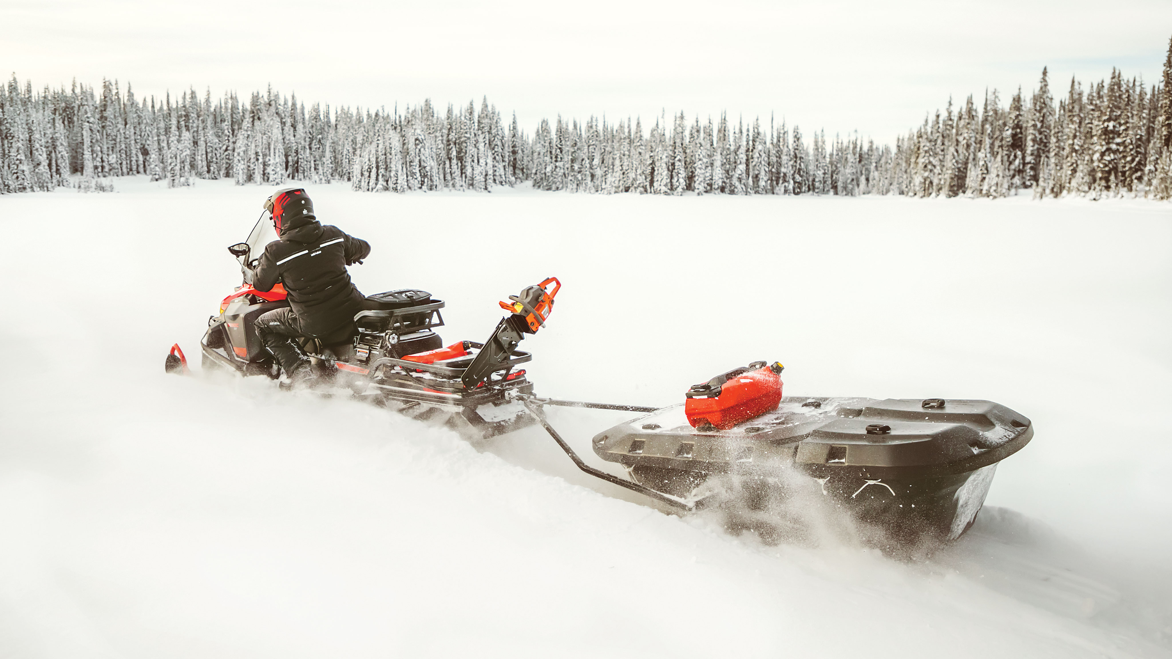 Man riding a Ski-Doo Skandic with a Sleigh in Deep-Snow