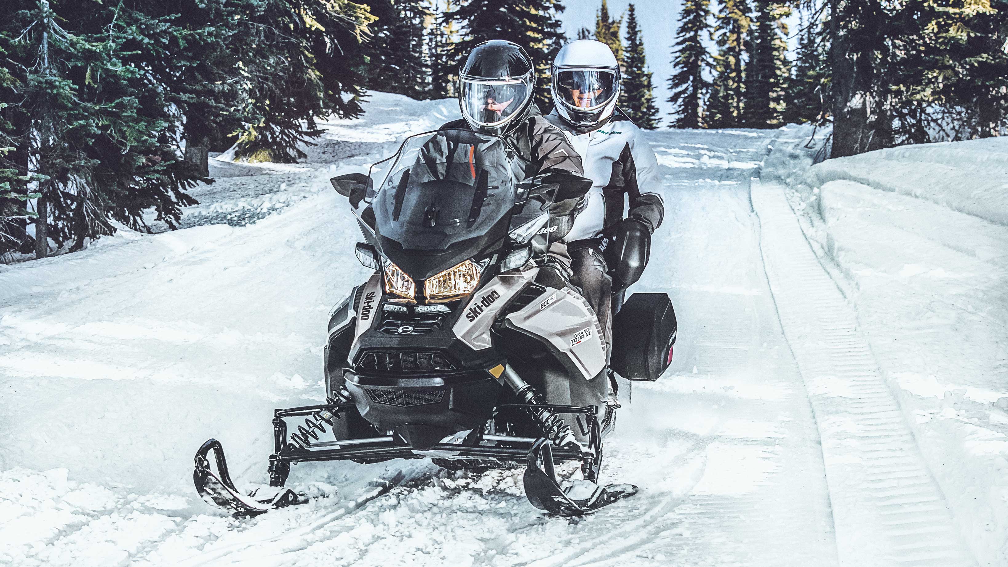 Couple & their 2022 Ski-Doo grand Touring on a trail