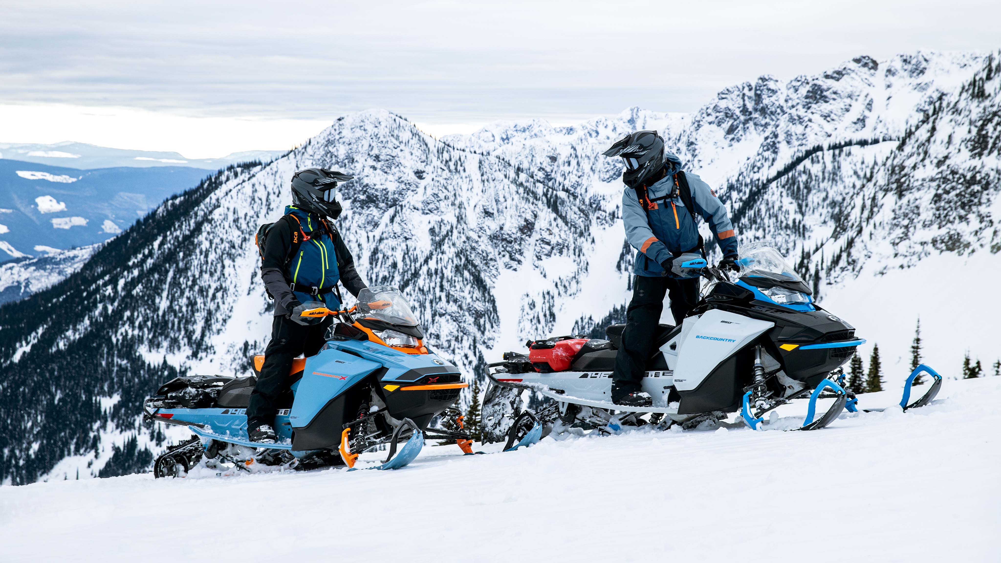 Two Ski-Doo riders stopped on a trail