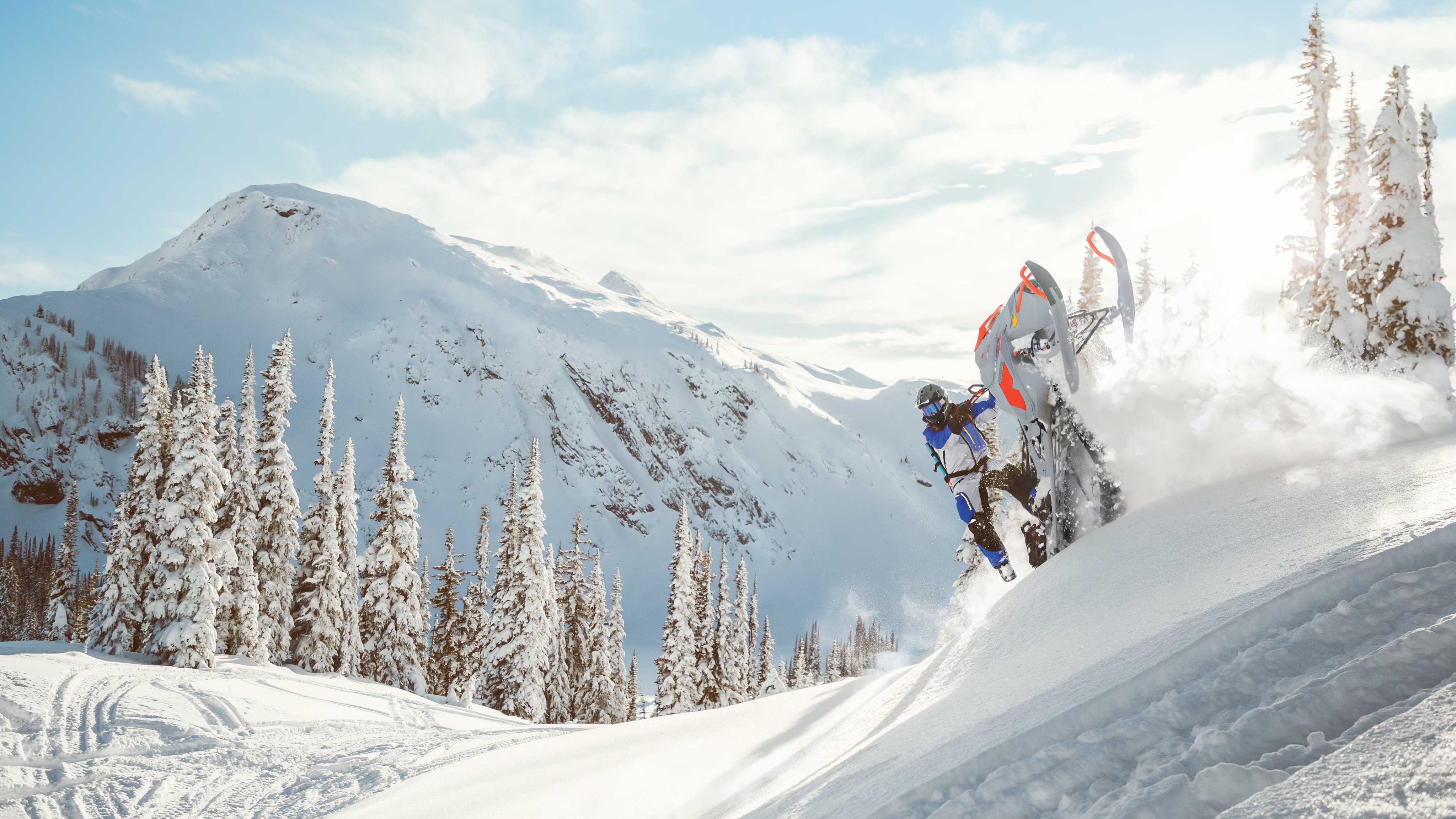 Возач кој ужива во длабочините на планинскиот снег со својата Ski-Doo моторна санка