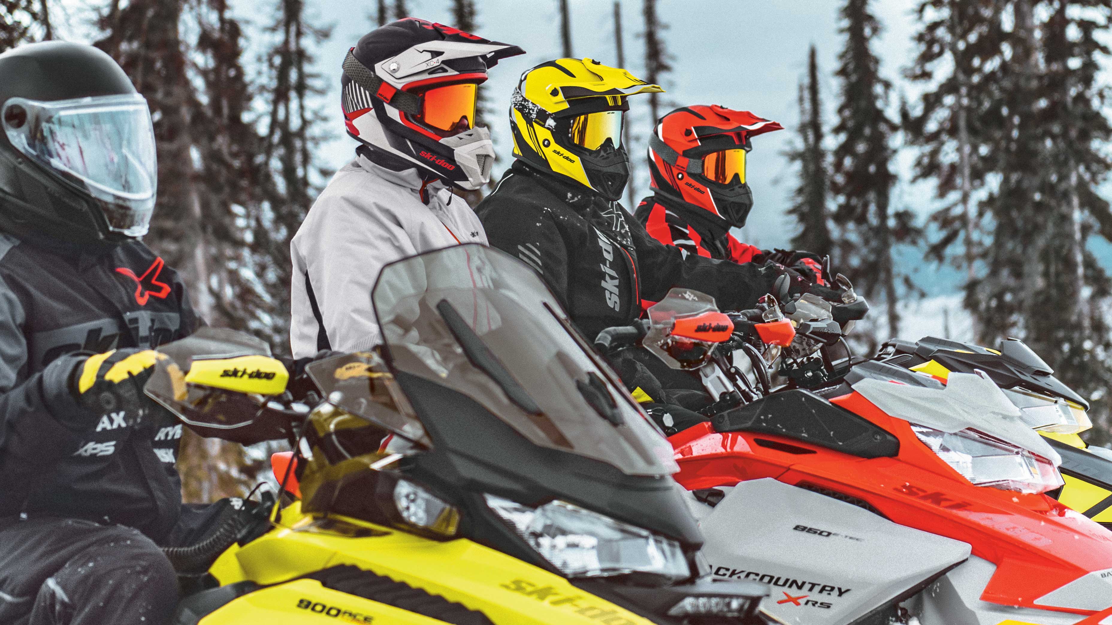4 riders riding a Ski-Doo snowmobile
