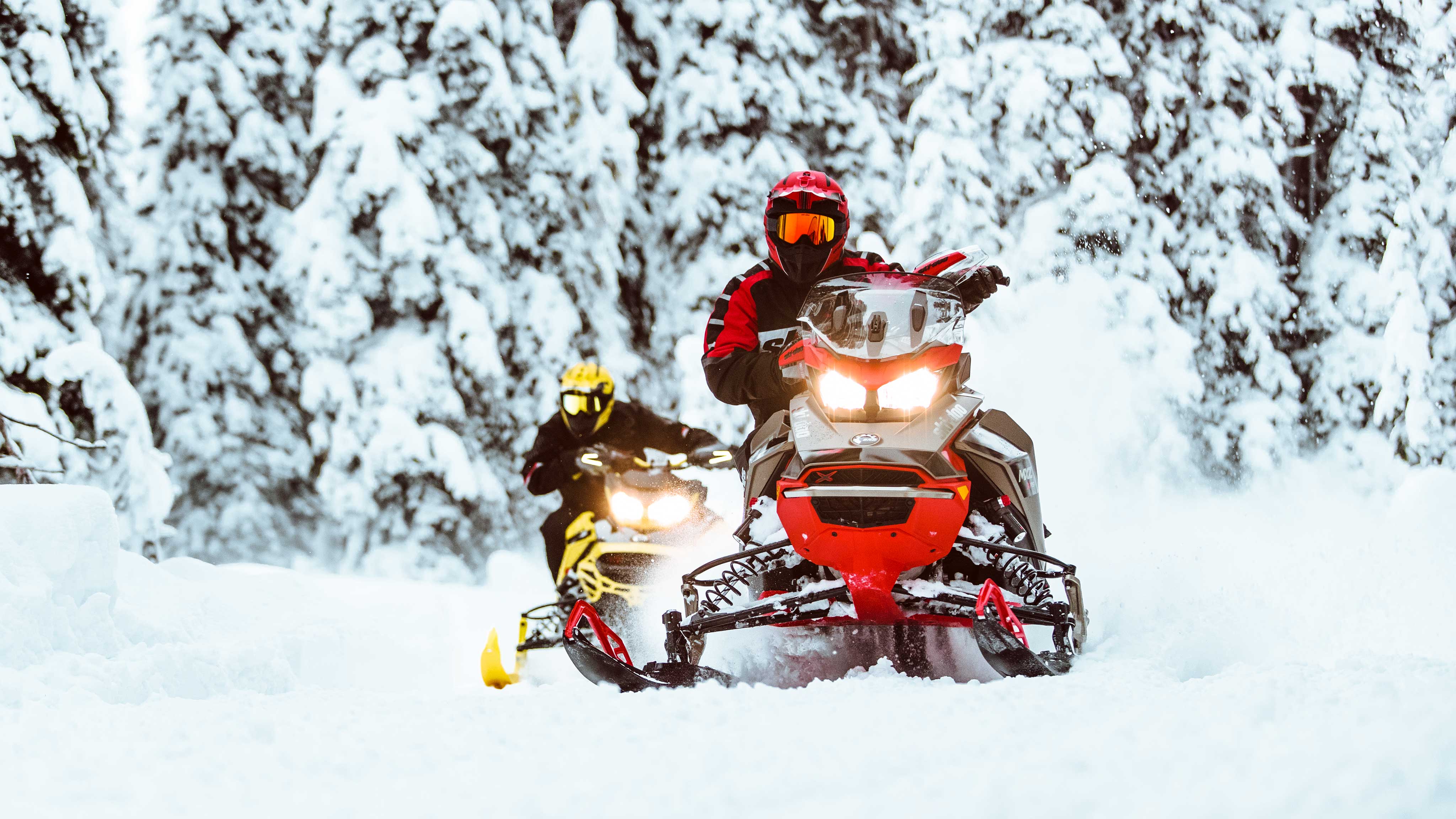 2 riders riding Ski-Doo snowmobile on a trail