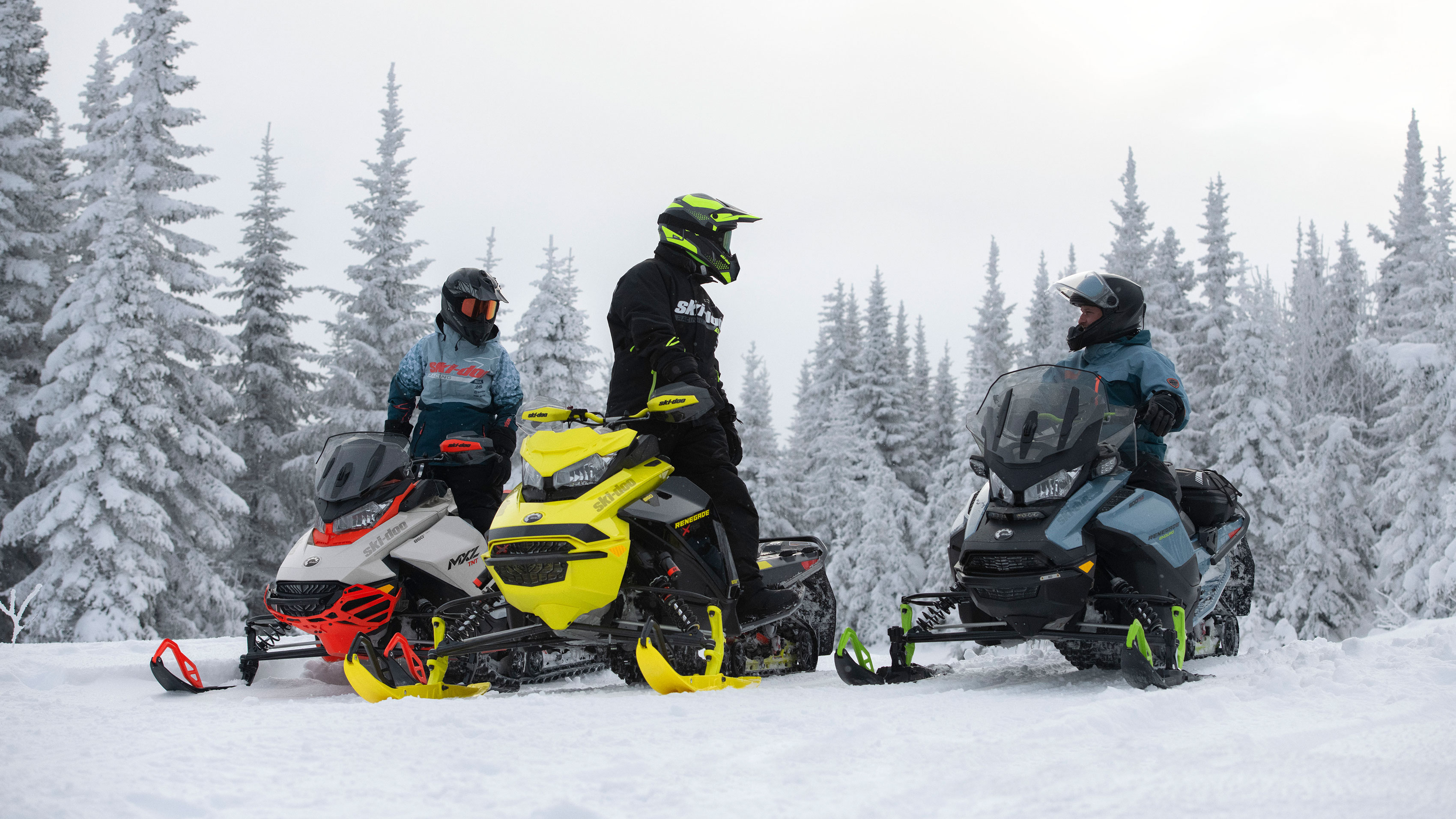 3 jazdci sa rozprávajú počas jazdy na skútroch Ski-Doo