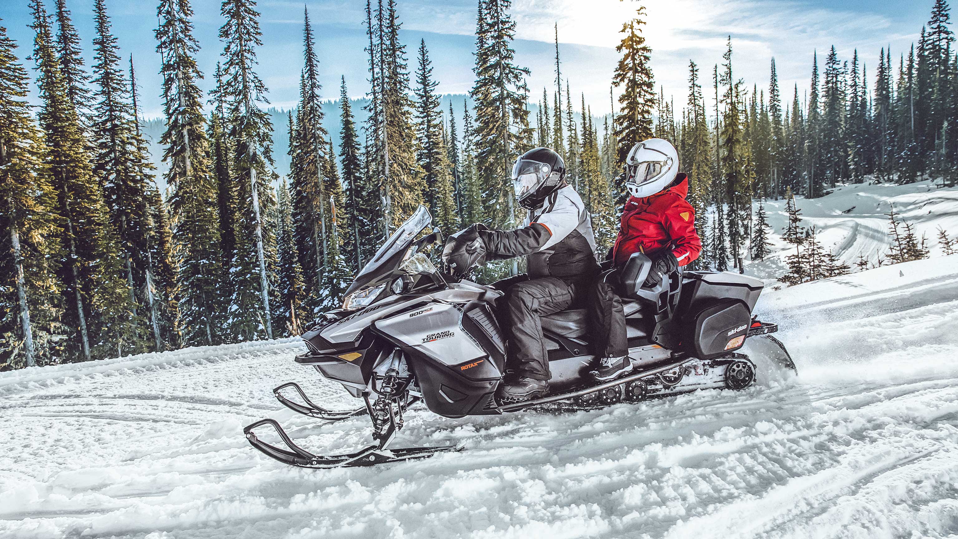 Couple riding 2022 Ski-Doo grand Touring snowmobile