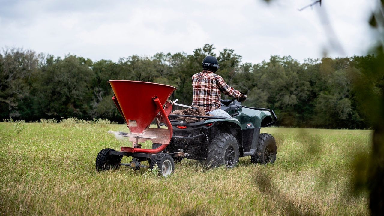 Farmár používa jeho Can-Am Outlander PRO XU, aby zasial na svoje pole a používa pri tom obmedzovač rýchlosti