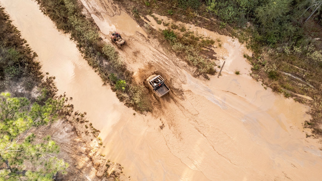 Aerial view of a 2023 Can-Am Outlander X mr 700 ATV crossing a mud trail