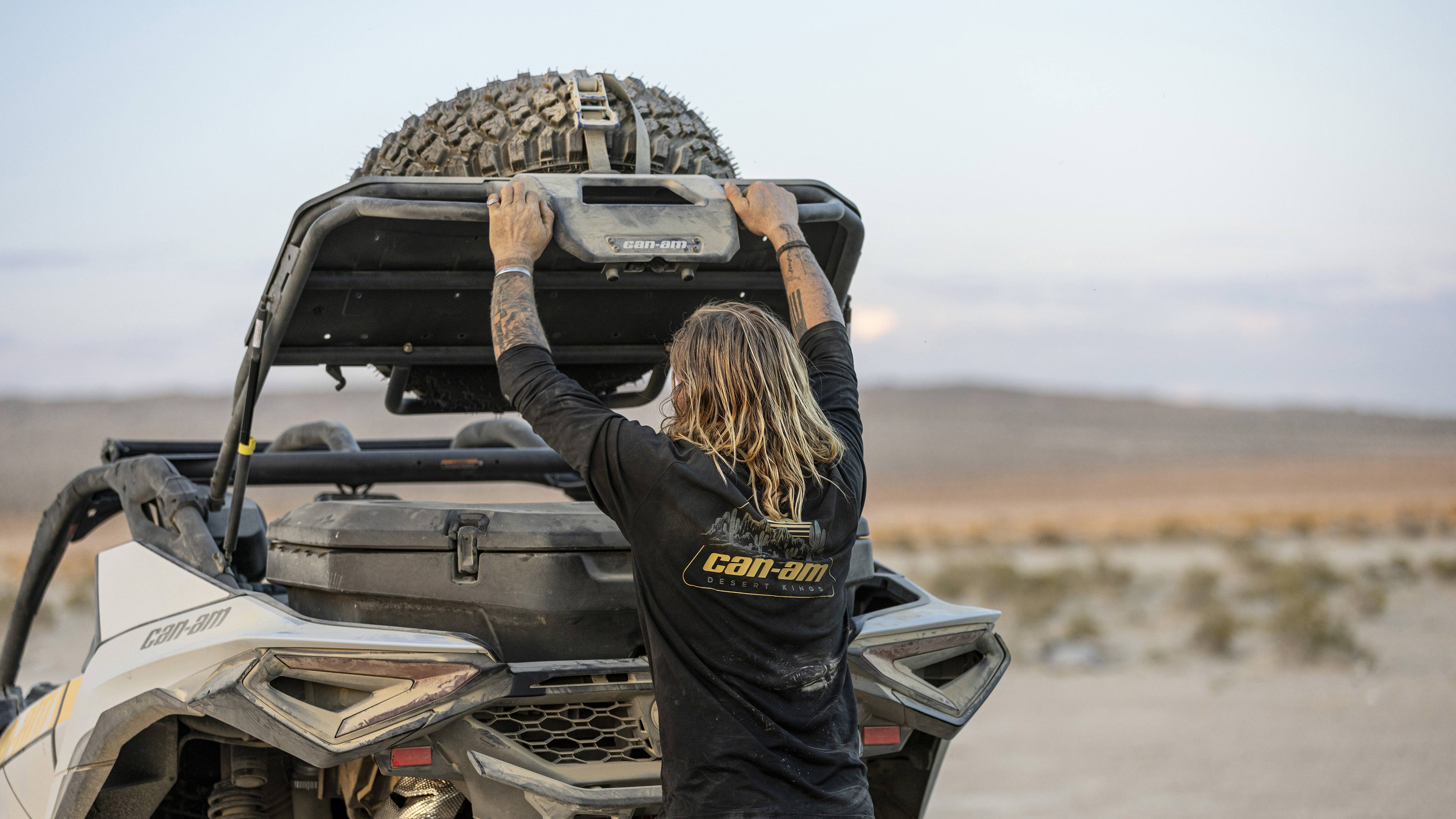 Rider reaching for a LinQ storage box in the back of his 2024 Can-Am Maverick R SxS