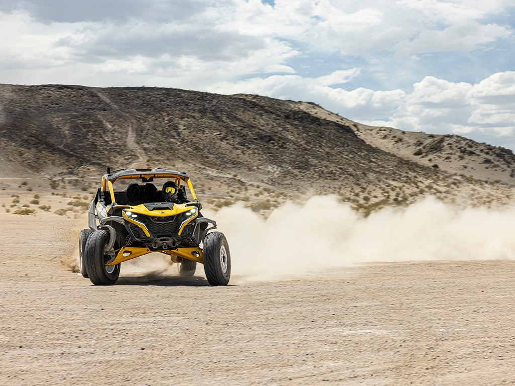 A rider driving a 2024 Can-Am Maverick R SxS vehicle in the desert