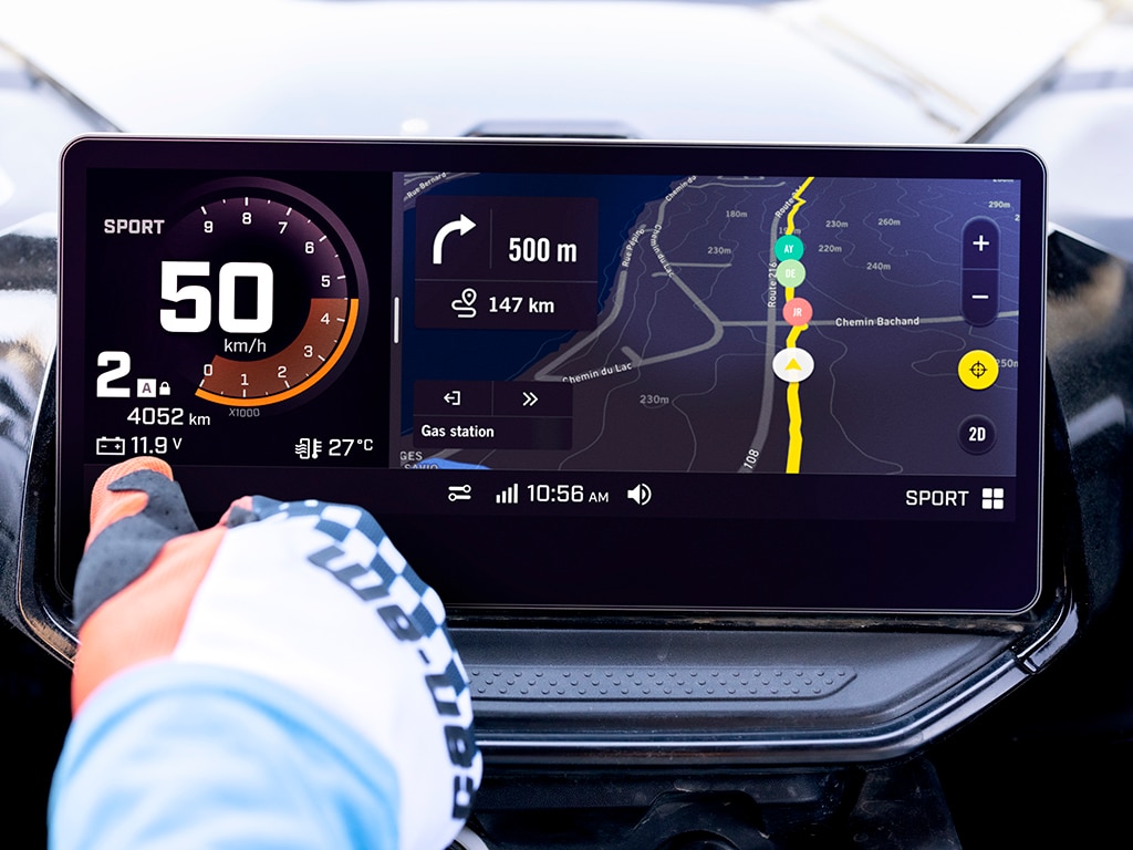 A Can-Am rider using the touchscreen and showing the drive mode option