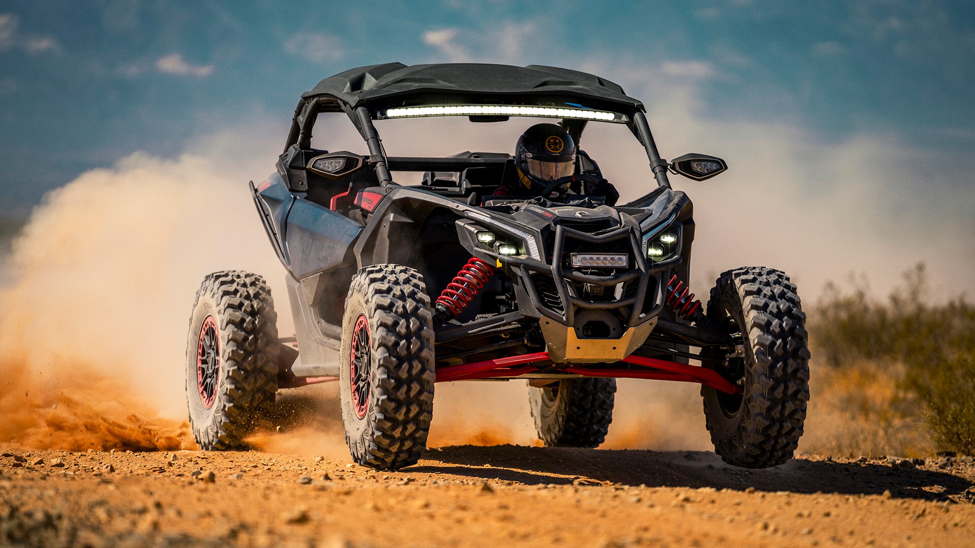 A Can-Am Maverick X RS driving through desert sand