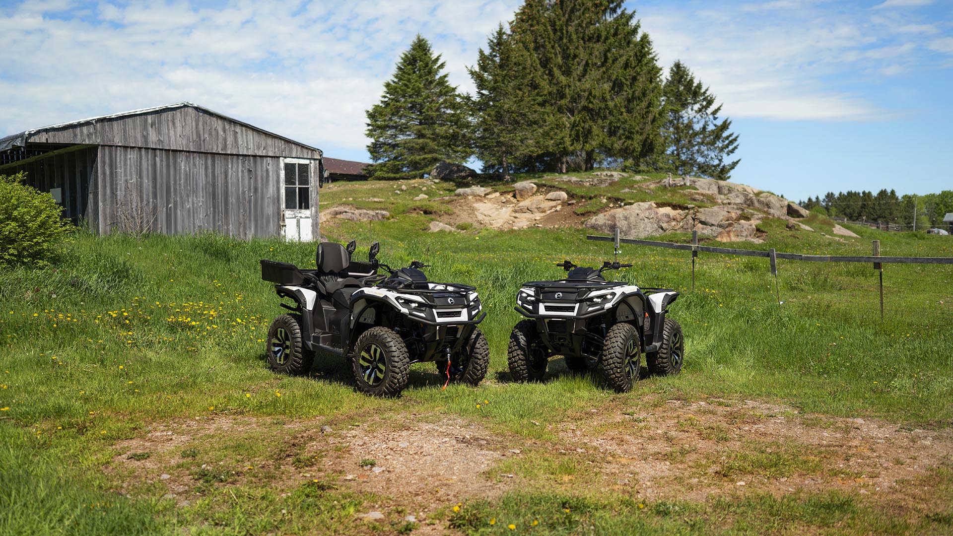 Two Can-Am Outlander Electric ATVs parked in the grass
