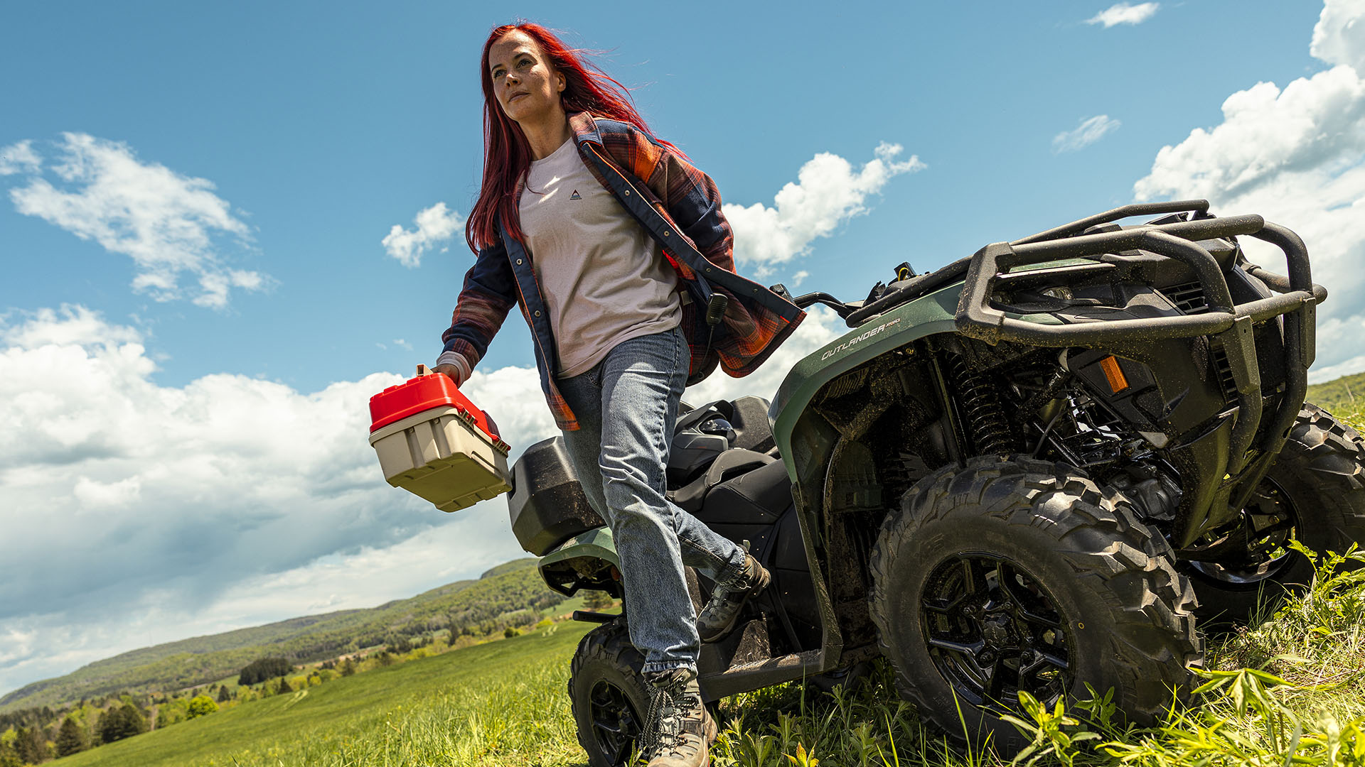 A woman who has just steeped out from her 2026 Can-Am Outlander MAX PRO XU HD7 on her land
