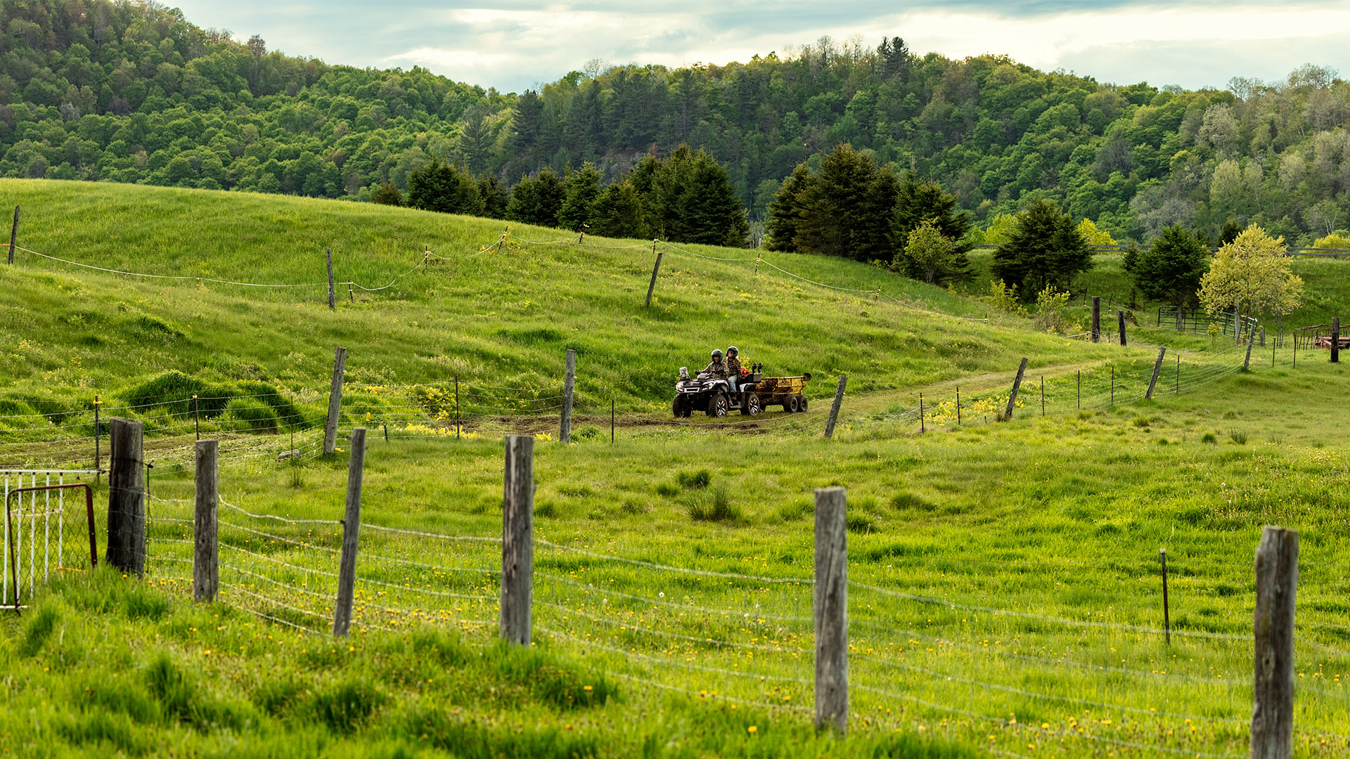 A 2026 Can-Am Outlander Electric pulling load on a farm