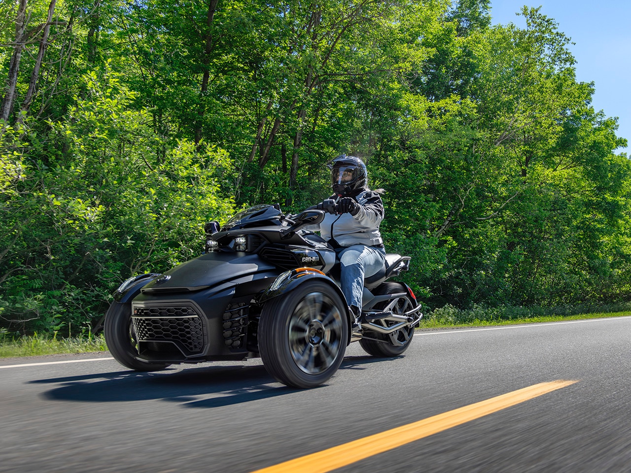 A woman riding the latest Can-Am Spyder F3 3-wheel motorcycle