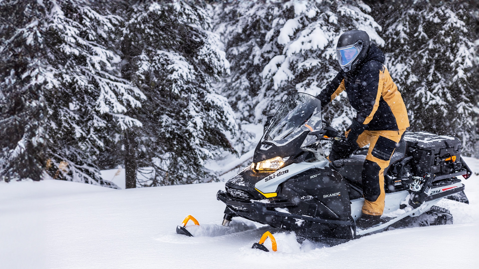 Jazdec jazdí na skútri Ski-Doo Skandic v zasneženom lese